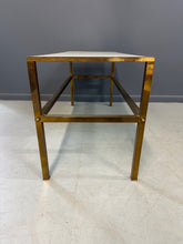 Load image into Gallery viewer, 1970s brass console table featuring a sleek white Vitrolite glass top and a minimalist rectangular brass frame with clean lines and mid-century modern influence