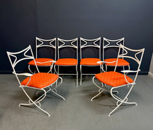 Load image into Gallery viewer, 1940s French mid-century modern outdoor dining set featuring six white wrought iron chairs with orange diamond-patterned cushions and a matching table with decorative curved frames