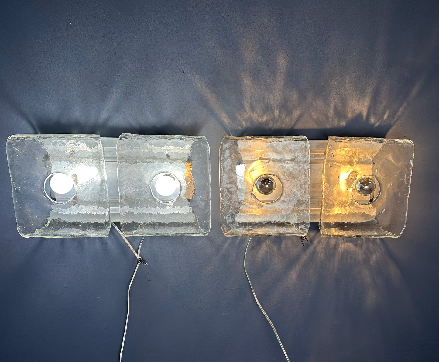 Set of two vintage 1960s Carlo Nason for Kalmar Franken glass wall lights featuring textured square glass shades mounted on a horizontal metal fixture