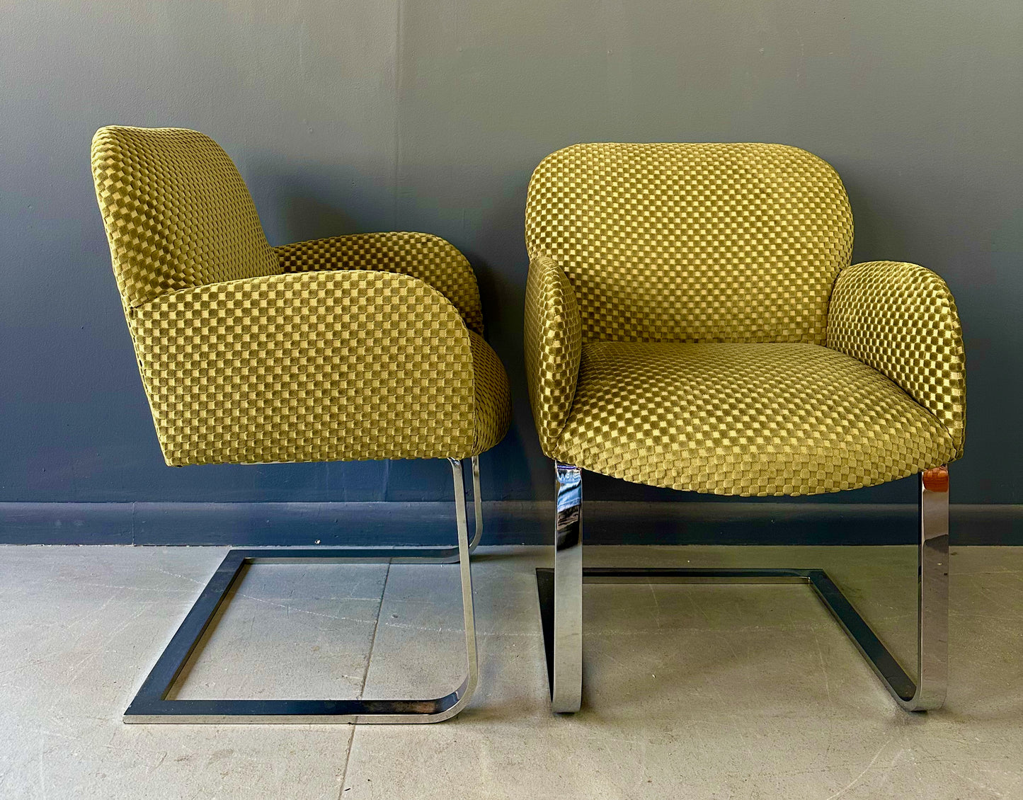Pair of mid-century modern flat bar lounge chairs in the style of Milo Baughman, featuring chrome cantilever bases and gold checkered upholstery