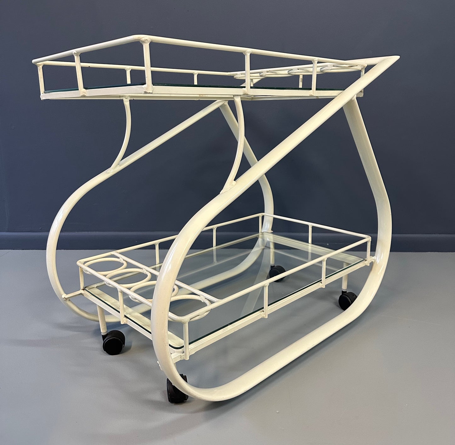 Vintage 1980s postmodern two-tier bar cart with curvy metal frame and glass shelves, attributed to Woodard