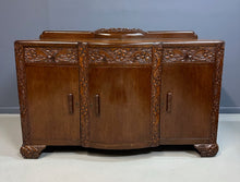 Load image into Gallery viewer, 1920s English Art Nouveau sideboard in oak with ornate floral and vine hand-carving, three-door storage, and bun feet