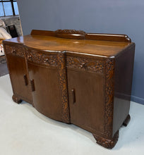 Load image into Gallery viewer, 1920s English Art Nouveau sideboard in oak with ornate floral and vine hand-carving, three-door storage, and bun feet