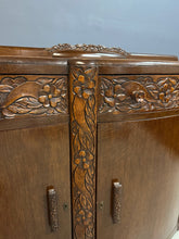 Load image into Gallery viewer, 1920s English Art Nouveau sideboard in oak with ornate floral and vine hand-carving, three-door storage, and bun feet