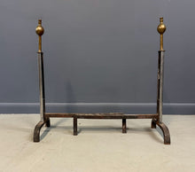 Load image into Gallery viewer, Pair of Machine Age andirons made of polished steel columns with spherical brass finials on top, supported by rugged iron bases with a minimalist, industrial design.