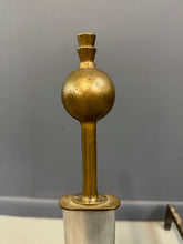 Load image into Gallery viewer, Pair of Machine Age andirons made of polished steel columns with spherical brass finials on top, supported by rugged iron bases with a minimalist, industrial design.