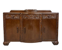 Load image into Gallery viewer, 1920s English Art Nouveau sideboard in oak with ornate floral and vine hand-carving, three-door storage, and bun feet