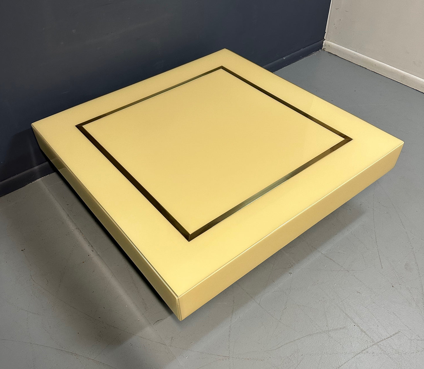 1970s Acrylic Stepped Cream Colored Coffee Table with Brass Ribbon Inlay
