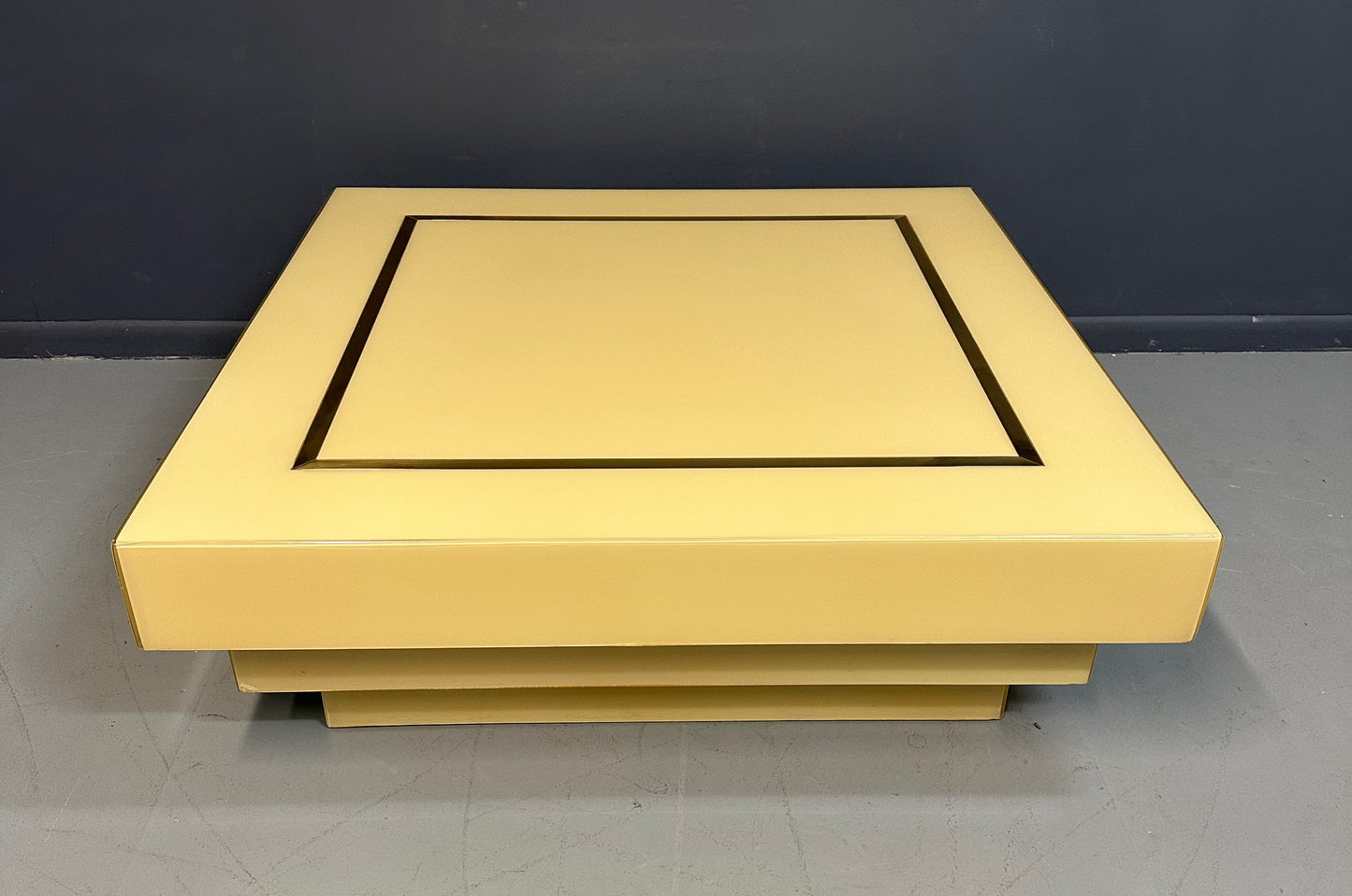 1970s Acrylic Stepped Cream Colored Coffee Table with Brass Ribbon Inlay