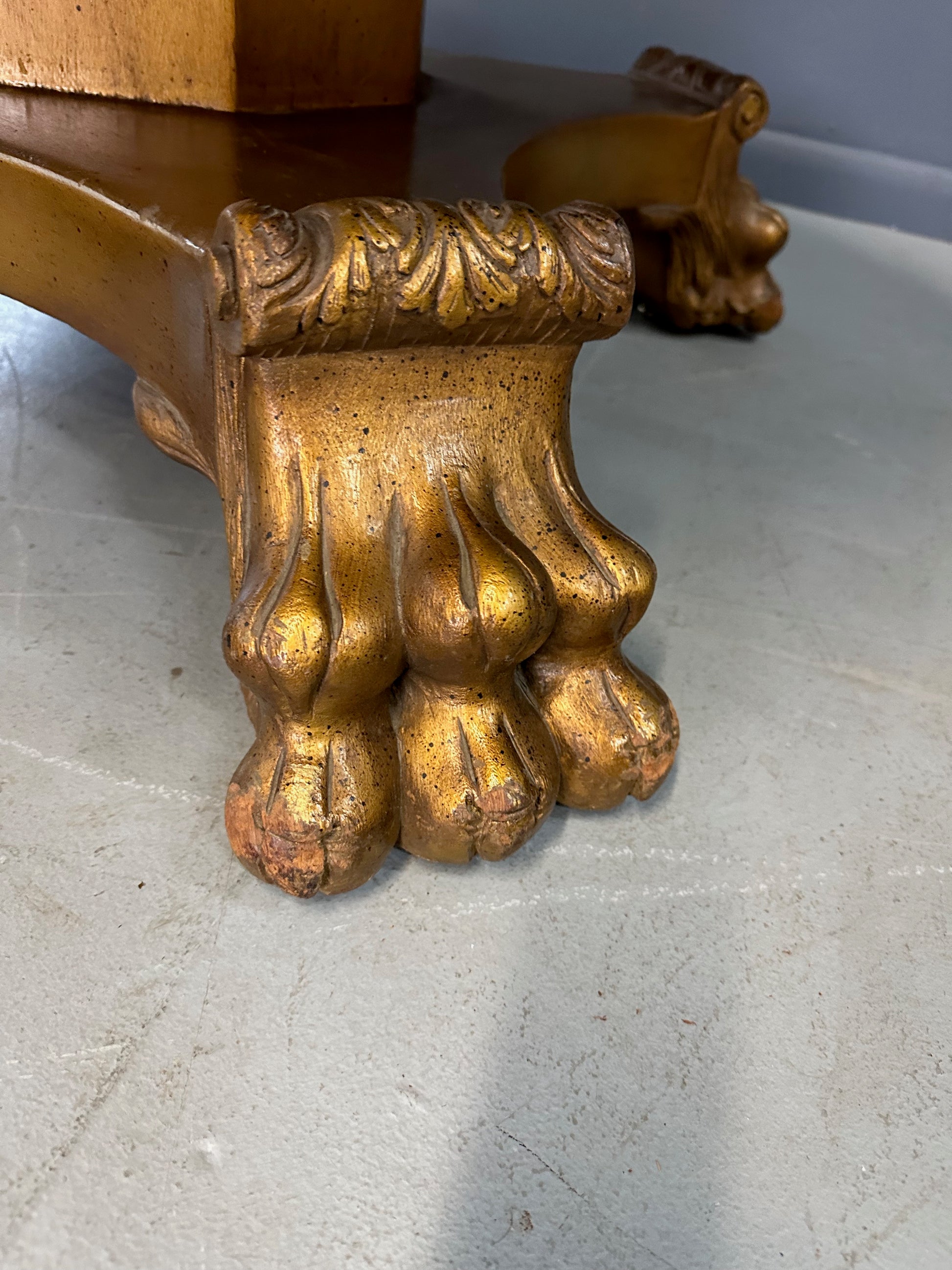 20th-century Empire-style Hollywood Regency coffee table featuring a round white marble top with elegant gray veining, supported by a gilded wood base with bold lion paw feet and neoclassical design elements