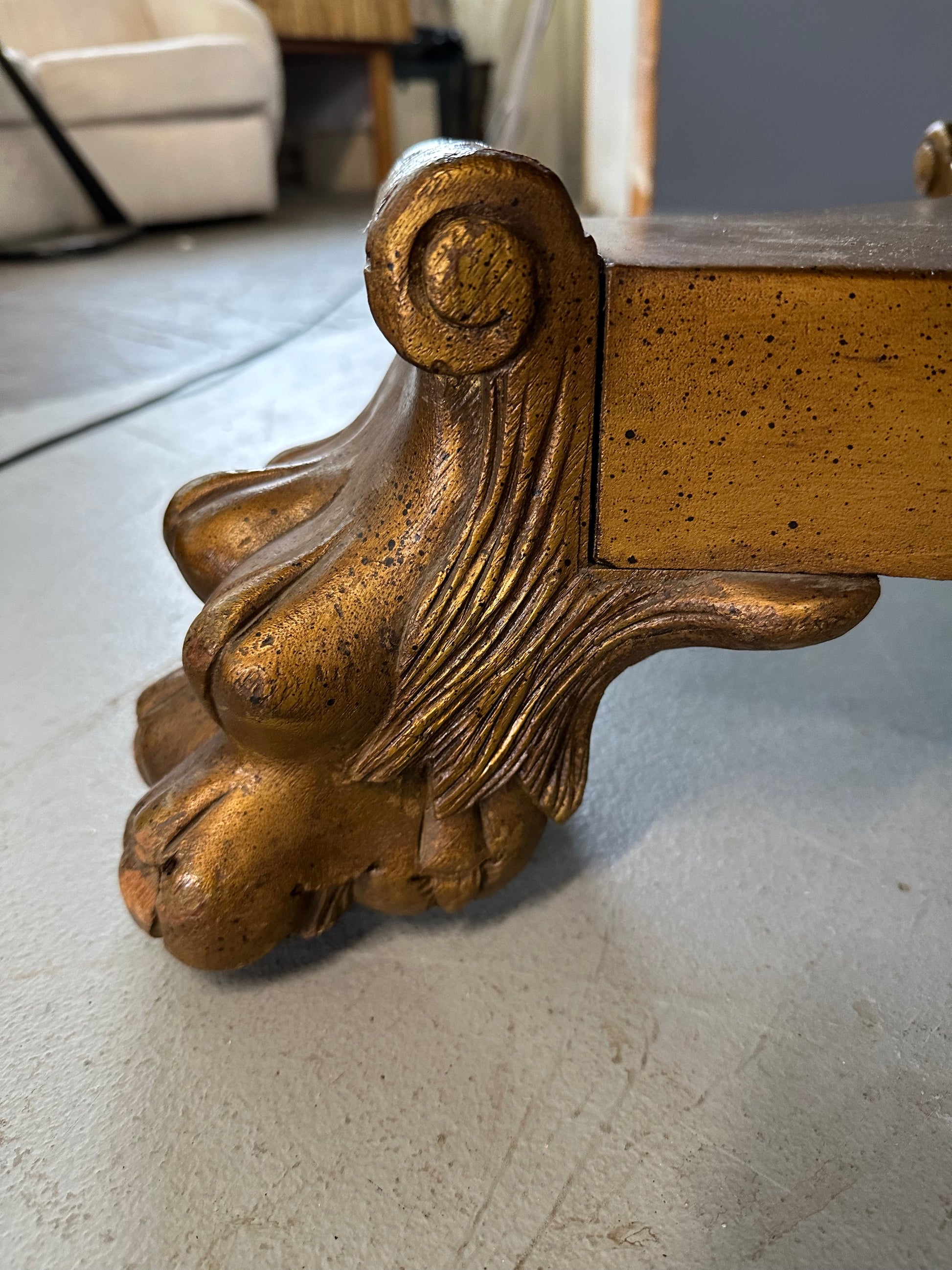 20th-century Empire-style Hollywood Regency coffee table featuring a round white marble top with elegant gray veining, supported by a gilded wood base with bold lion paw feet and neoclassical design elements