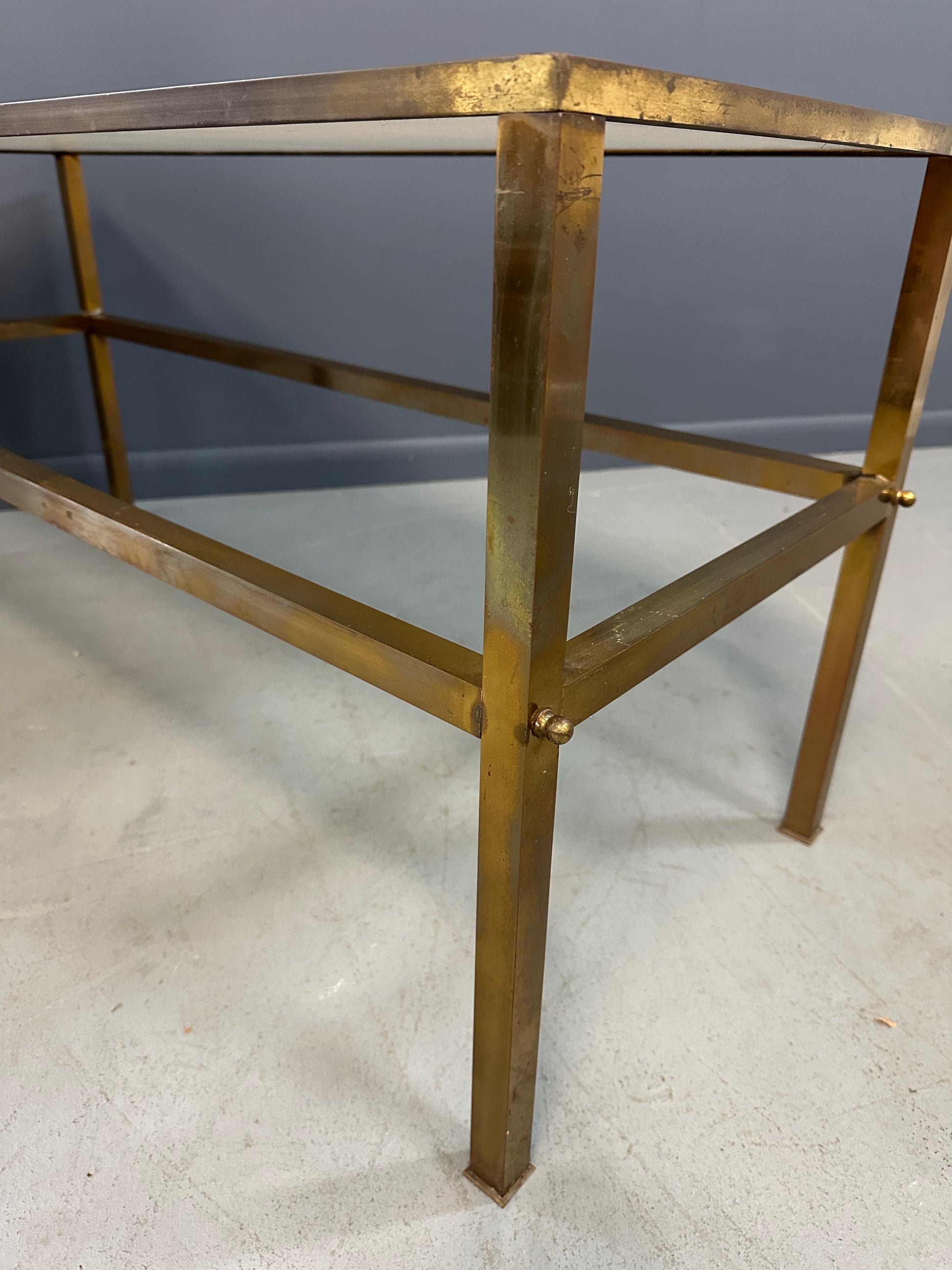 1970s brass console table featuring a sleek white Vitrolite glass top and a minimalist rectangular brass frame with clean lines and mid-century modern influence