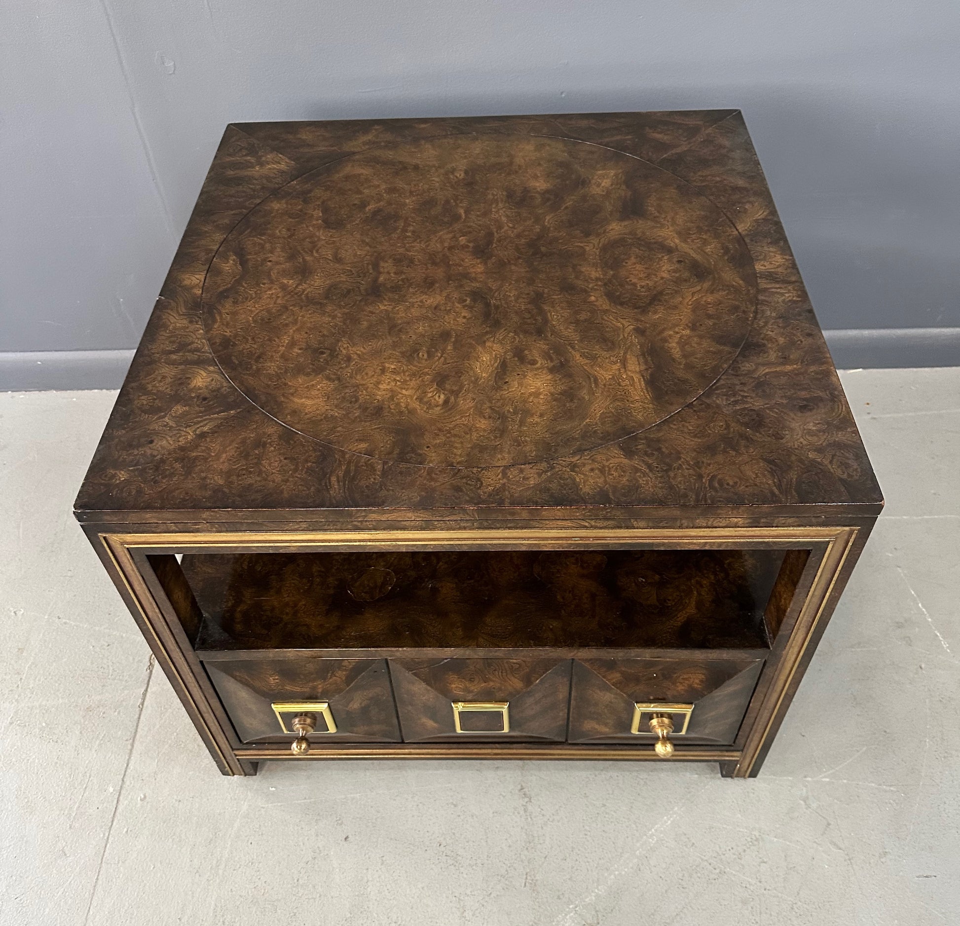 Large Mastercraft end table or nightstand featuring rich burl elm wood, brass trim, open shelving, and a drawer with geometric brass pulls