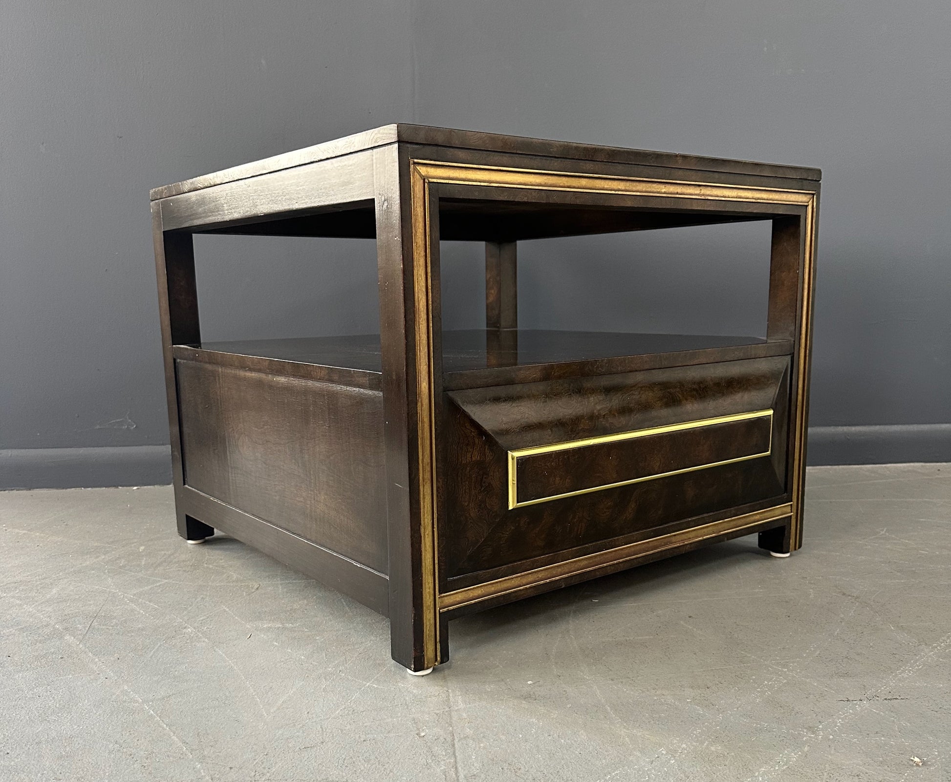 Large Mastercraft end table or nightstand featuring rich burl elm wood, brass trim, open shelving, and a drawer with geometric brass pulls