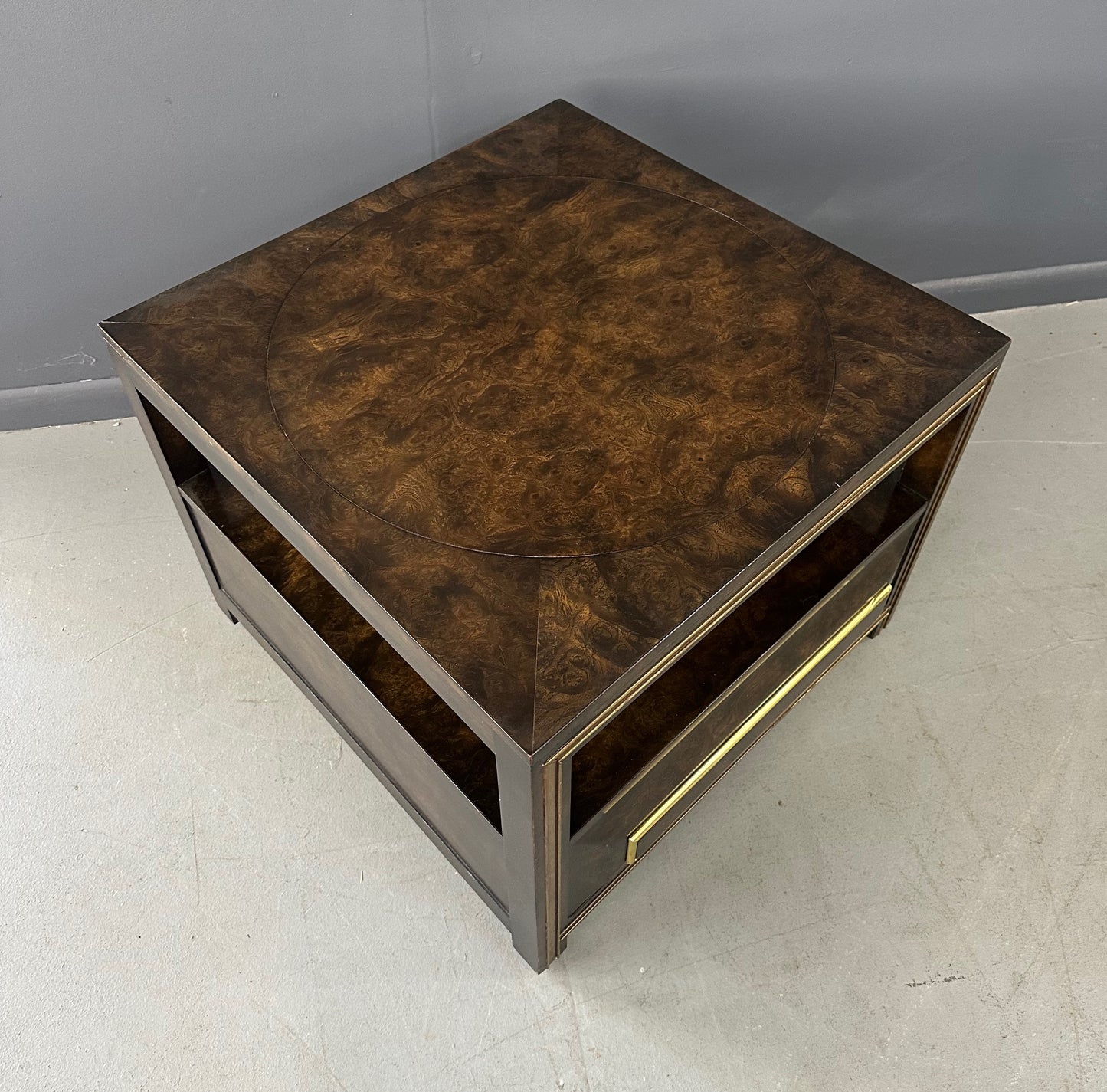 Large Mastercraft end table or nightstand featuring rich burl elm wood, brass trim, open shelving, and a drawer with geometric brass pulls