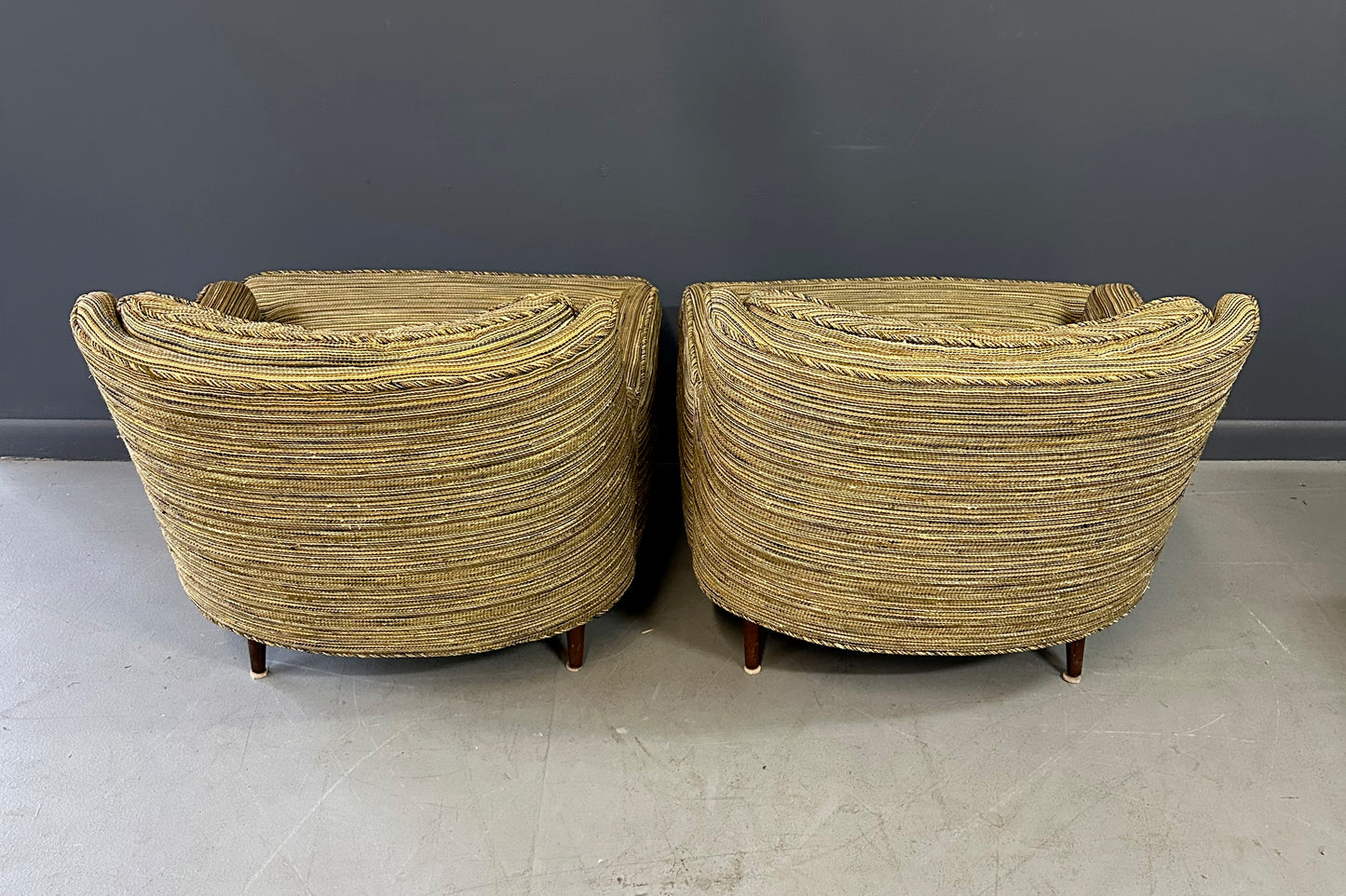 Pair of mid-century lounge chairs with tapered walnut legs, upholstered in original striped multicolor fabric with tufted backs and plush cushions