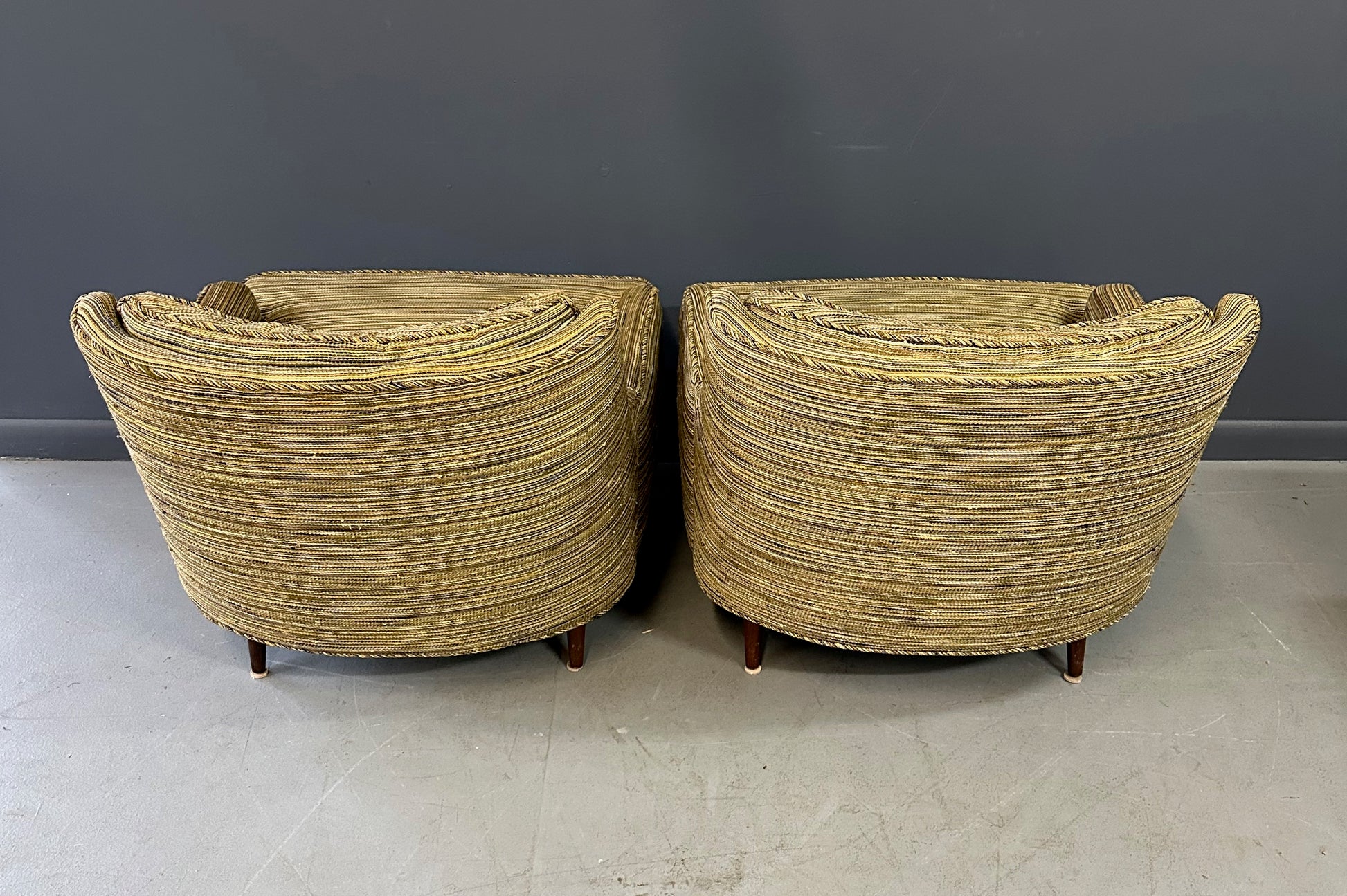 Pair of mid-century lounge chairs with tapered walnut legs, upholstered in original striped multicolor fabric with tufted backs and plush cushions