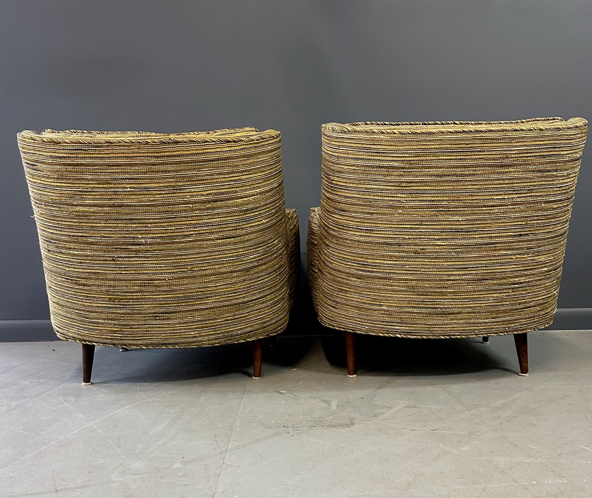 Pair of mid-century lounge chairs with tapered walnut legs, upholstered in original striped multicolor fabric with tufted backs and plush cushions
