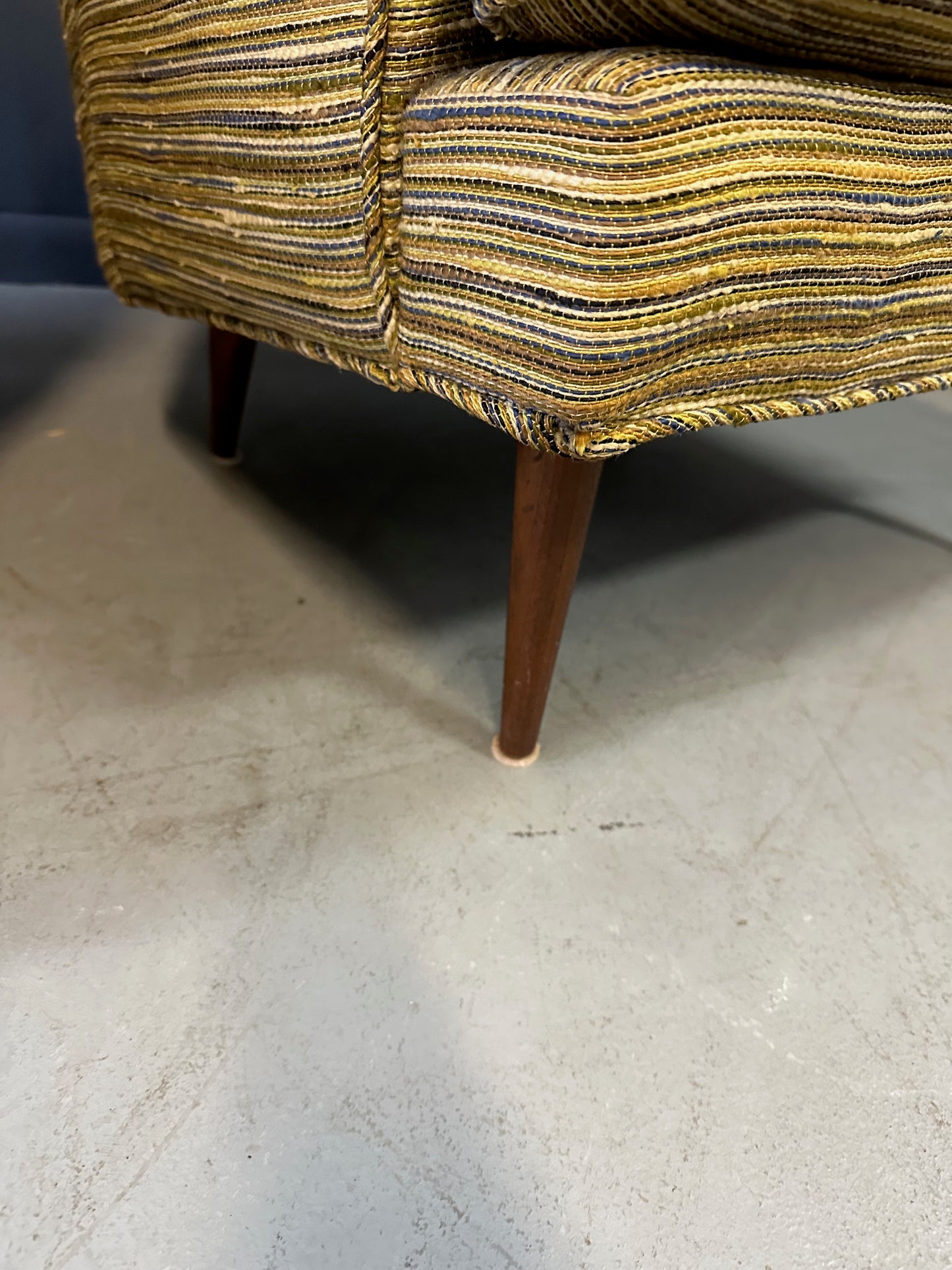 Pair of mid-century lounge chairs with tapered walnut legs, upholstered in original striped multicolor fabric with tufted backs and plush cushions