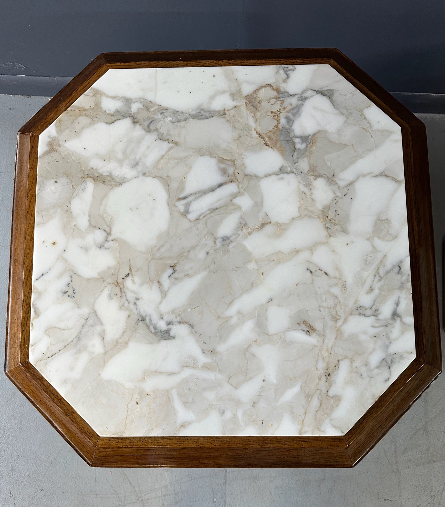Pair of Hollywood Regency octagonal side tables featuring sculpted wooden bases and creamy Calacatta marble tops with elegant veining.