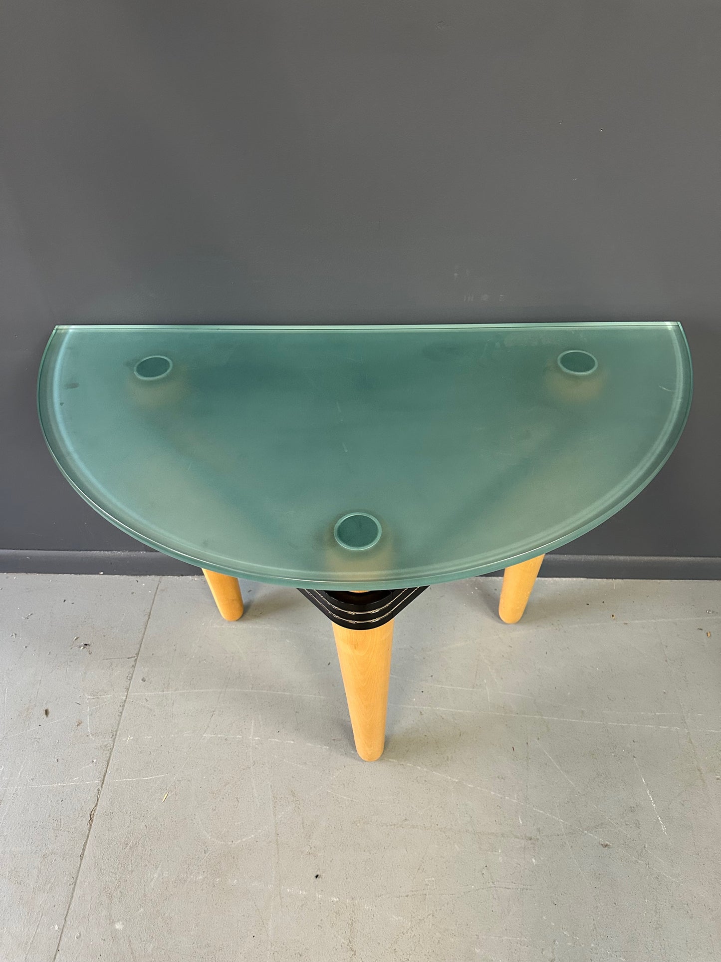 1990 demi-lune hall table designed by Kaiser Newman, featuring a curved green glass top, light beech wood legs, and a black lacquered frame with white inlay detailing