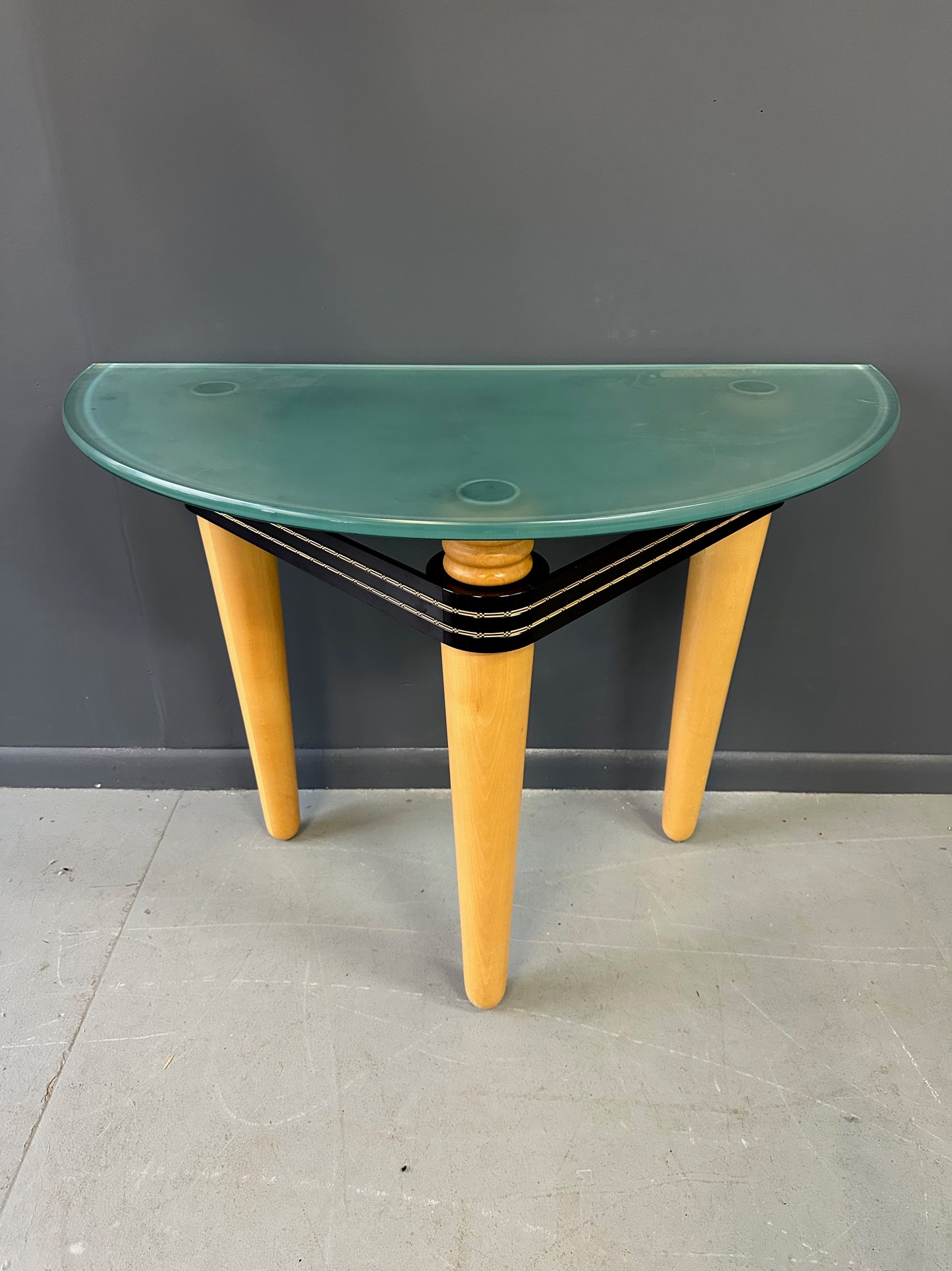 1990 demi-lune hall table designed by Kaiser Newman, featuring a curved green glass top, light beech wood legs, and a black lacquered frame with white inlay detailing