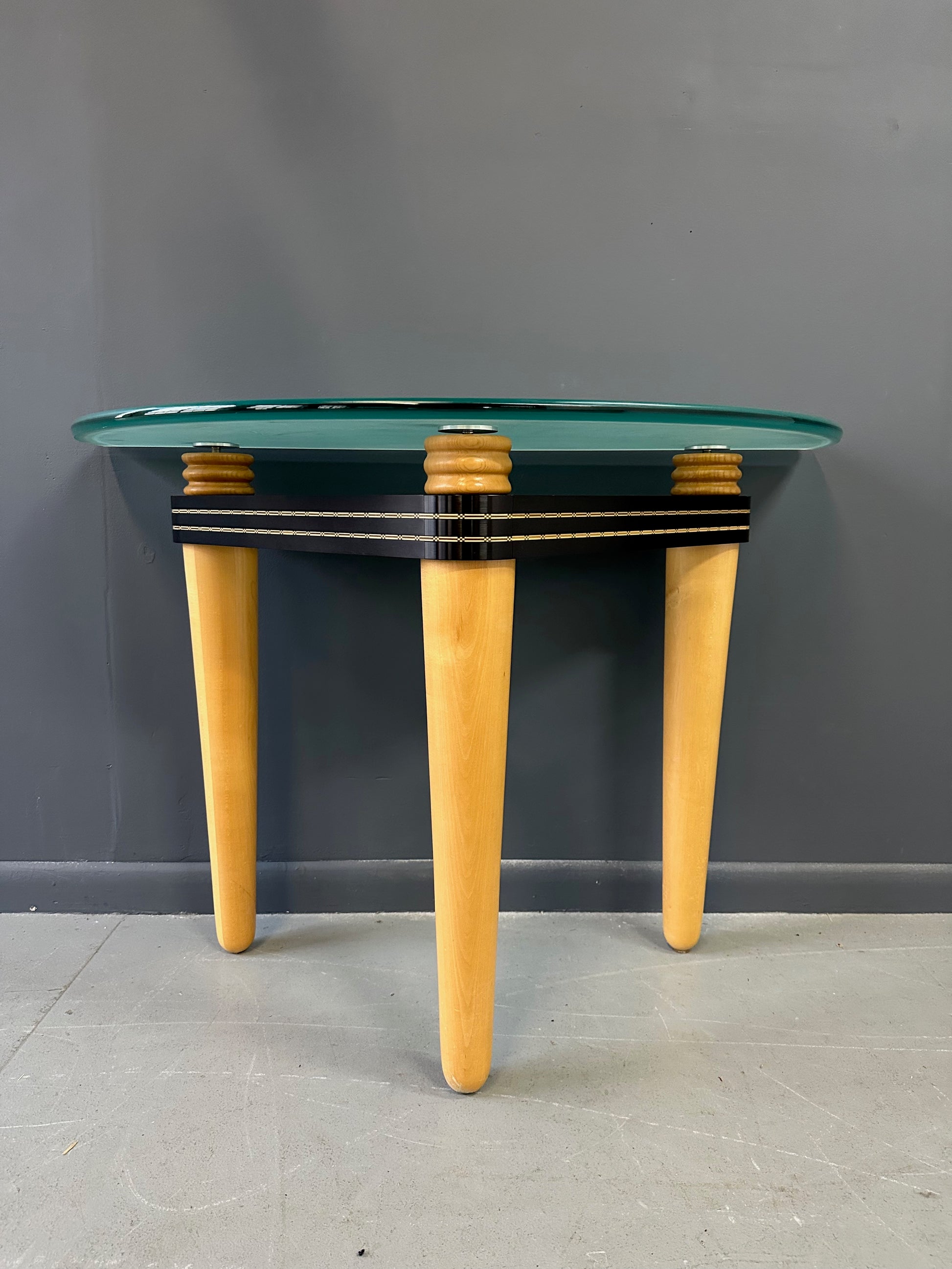 1990 demi-lune hall table designed by Kaiser Newman, featuring a curved green glass top, light beech wood legs, and a black lacquered frame with white inlay detailing