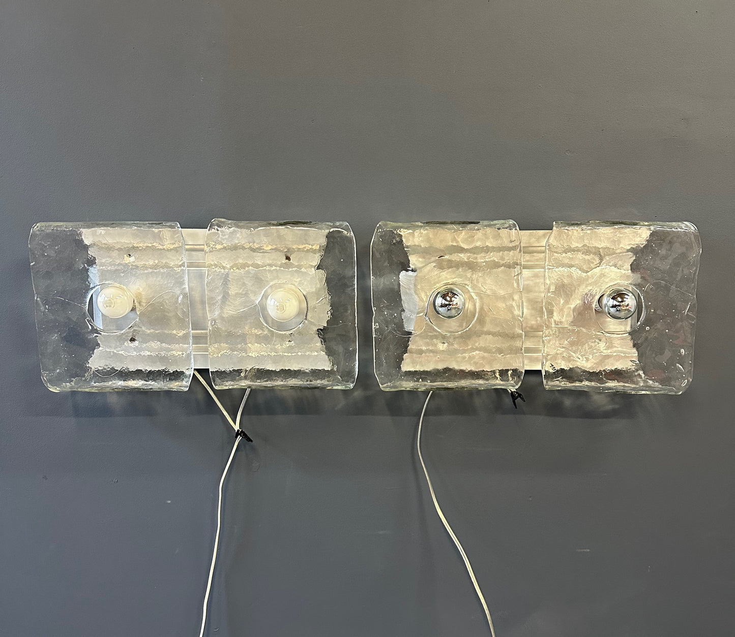 Set of two vintage 1960s Carlo Nason for Kalmar Franken glass wall lights featuring textured square glass shades mounted on a horizontal metal fixture