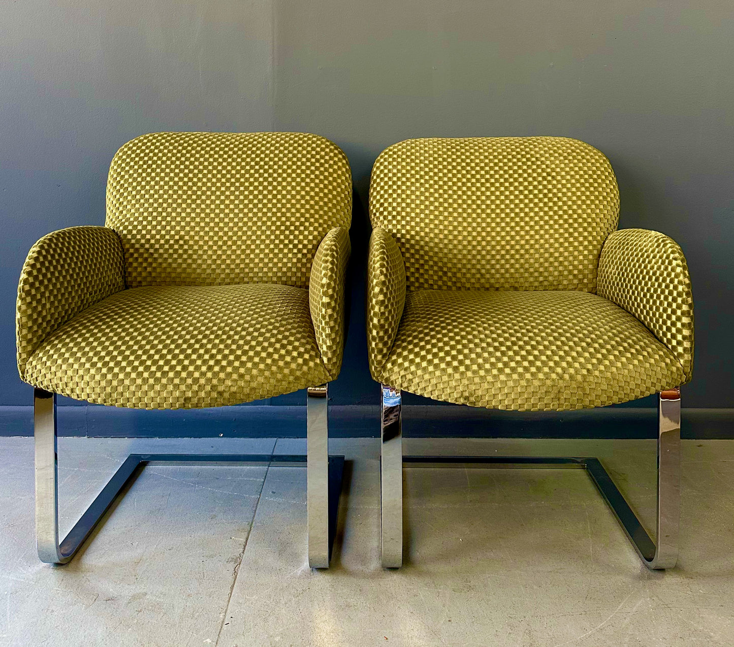 Pair of mid-century modern flat bar lounge chairs in the style of Milo Baughman, featuring chrome cantilever bases and gold checkered upholstery