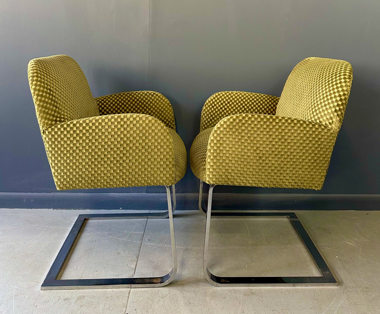 Pair of mid-century modern flat bar lounge chairs in the style of Milo Baughman, featuring chrome cantilever bases and gold checkered upholstery