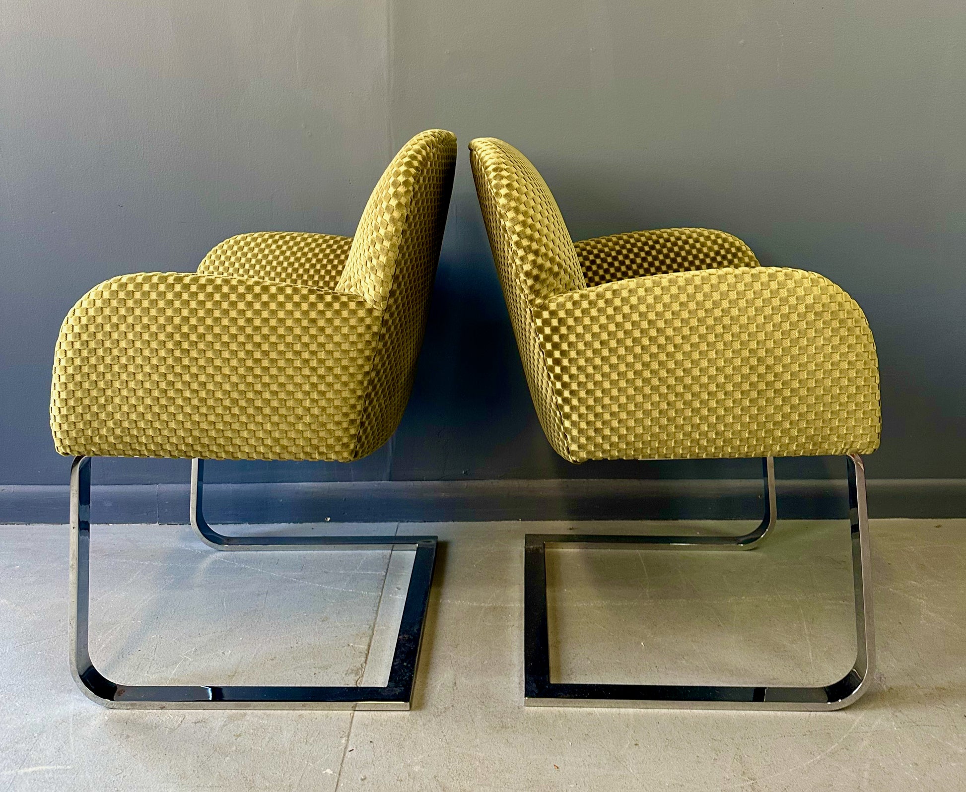 Pair of mid-century modern flat bar lounge chairs in the style of Milo Baughman, featuring chrome cantilever bases and gold checkered upholstery