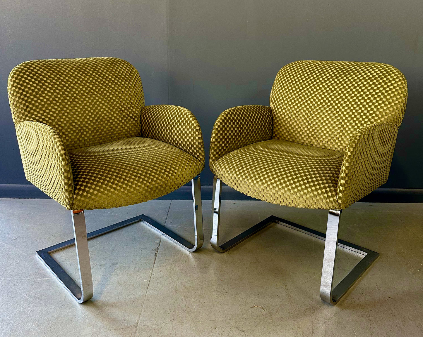 Pair of mid-century modern flat bar lounge chairs in the style of Milo Baughman, featuring chrome cantilever bases and gold checkered upholstery