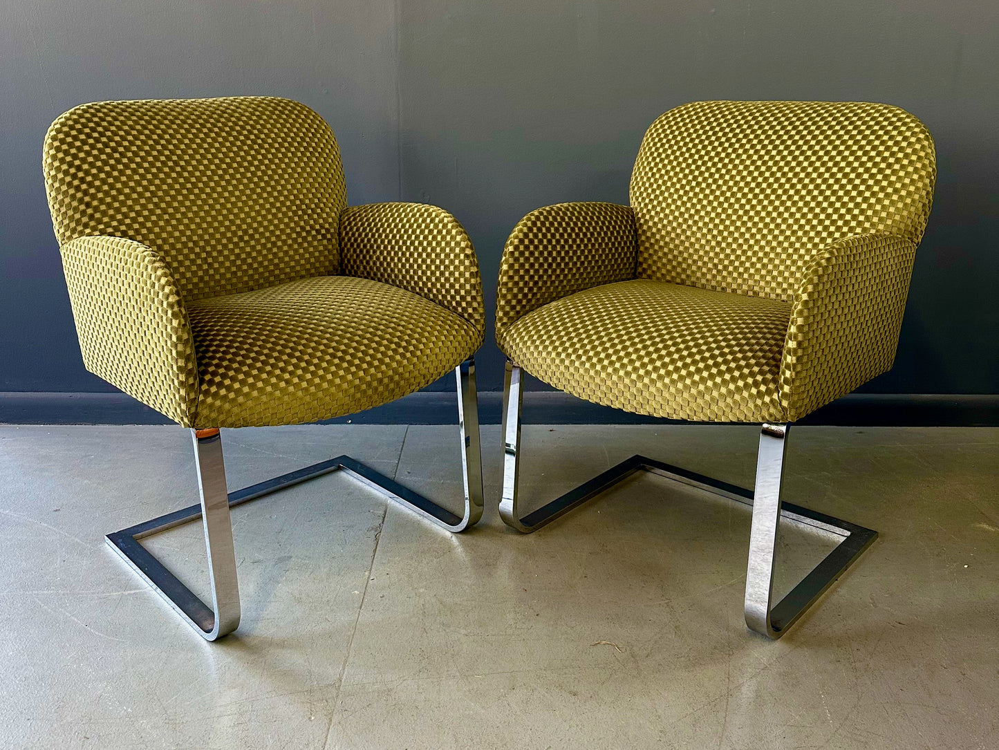 Pair of mid-century modern flat bar lounge chairs in the style of Milo Baughman, featuring chrome cantilever bases and gold checkered upholstery