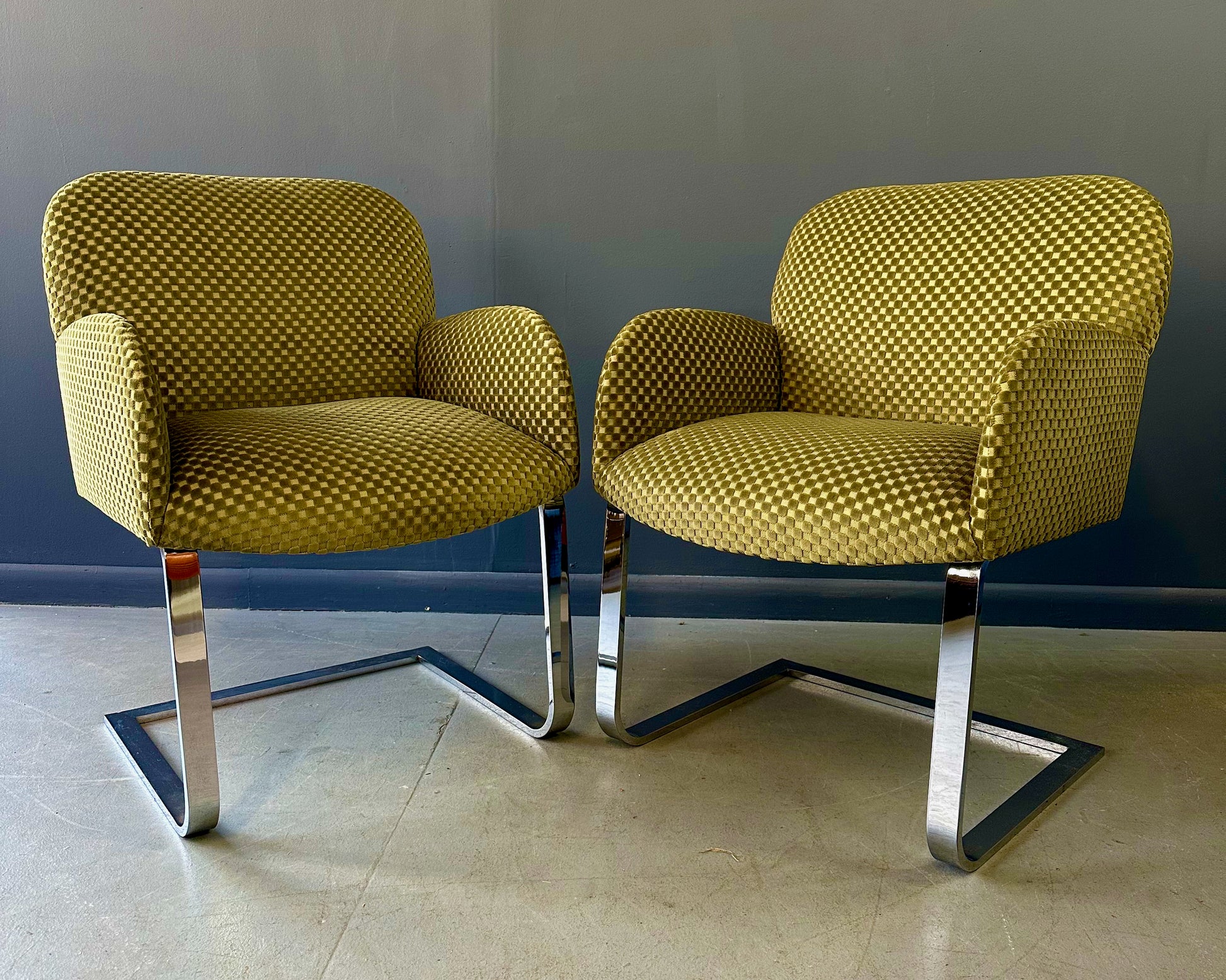 Pair of mid-century modern flat bar lounge chairs in the style of Milo Baughman, featuring chrome cantilever bases and gold checkered upholstery