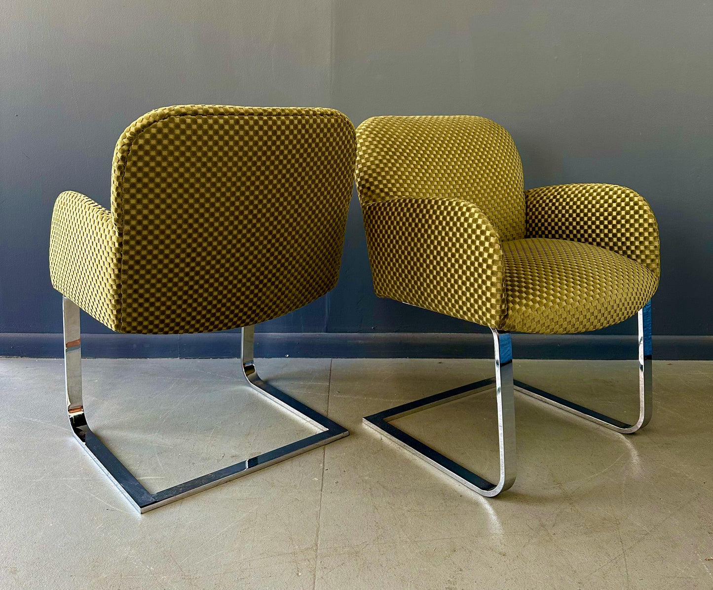 Pair of mid-century modern flat bar lounge chairs in the style of Milo Baughman, featuring chrome cantilever bases and gold checkered upholstery