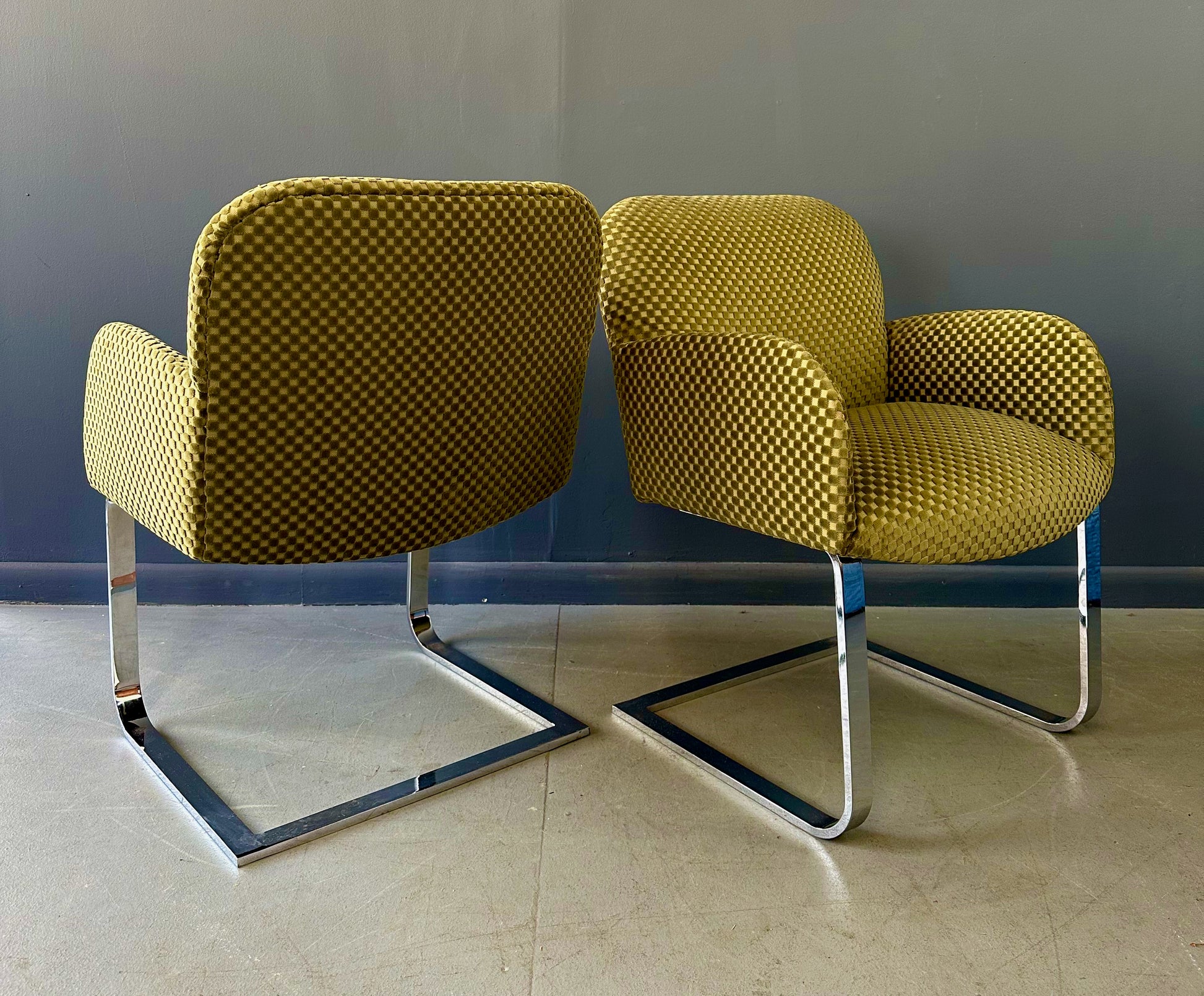 Pair of mid-century modern flat bar lounge chairs in the style of Milo Baughman, featuring chrome cantilever bases and gold checkered upholstery