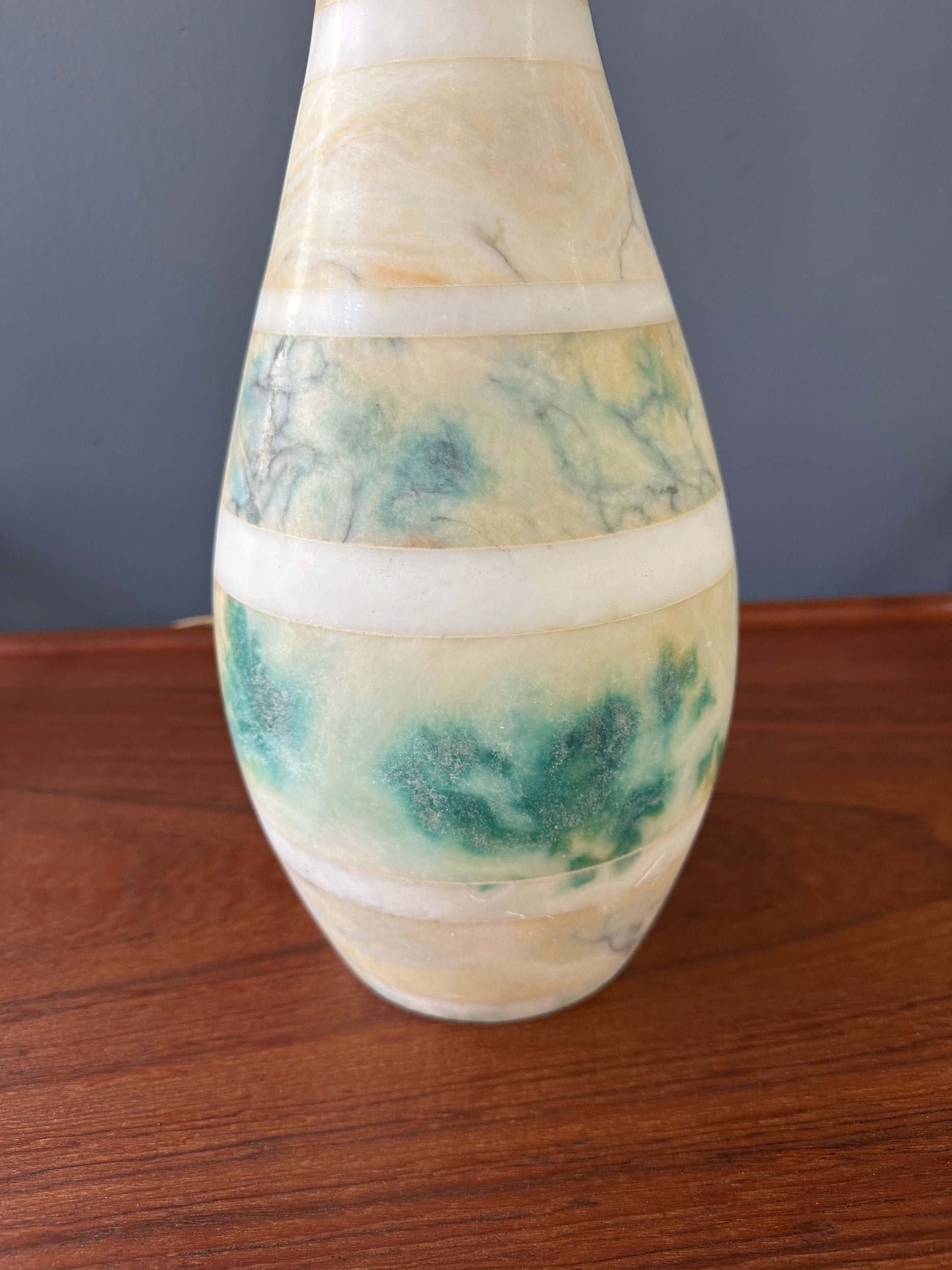 Mid-century Italian tall table lamp featuring a stacked marble design in blue, green, and beige tones, with a slender neck 