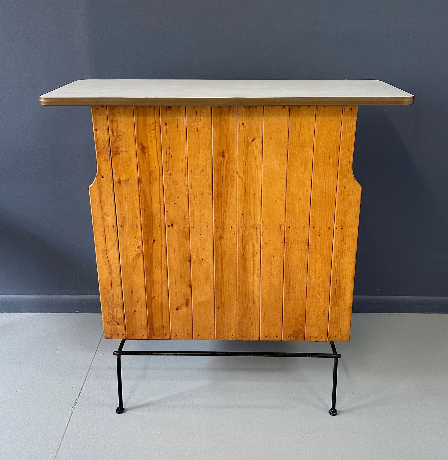 Mid-Century Modern dry bar console with matching stool by Arthur Umanoff, 1950s, featuring slatted wood panels, iron legs, and a curved wooden seat and backrest with minimalist black metal framing