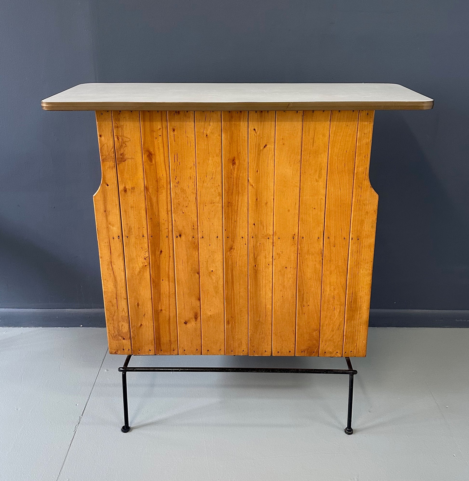 Mid-Century Modern dry bar console with matching stool by Arthur Umanoff, 1950s, featuring slatted wood panels, iron legs, and a curved wooden seat and backrest with minimalist black metal framing