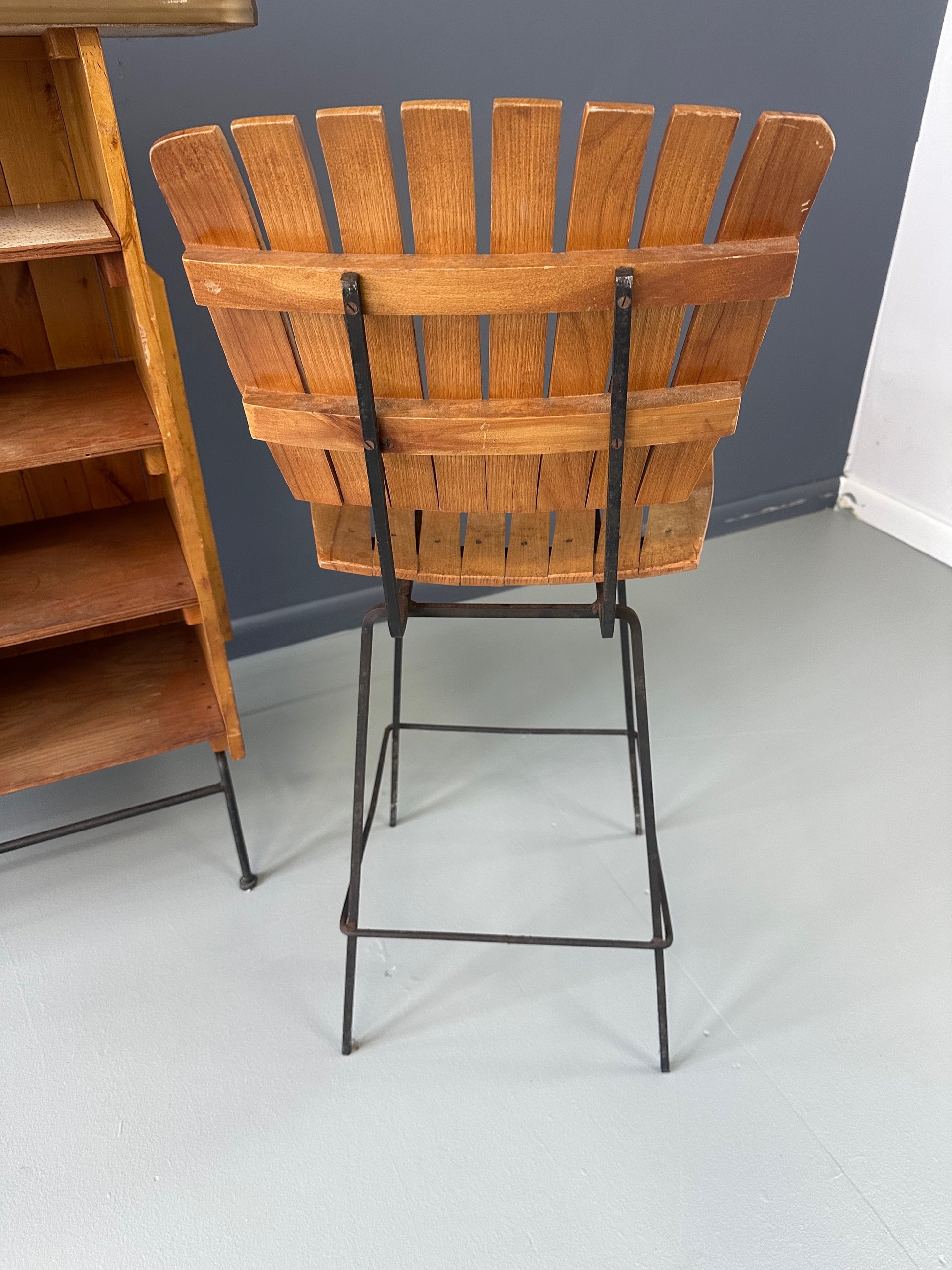 Mid-Century Modern dry bar console with matching stool by Arthur Umanoff, 1950s, featuring slatted wood panels, iron legs, and a curved wooden seat and backrest with minimalist black metal framing