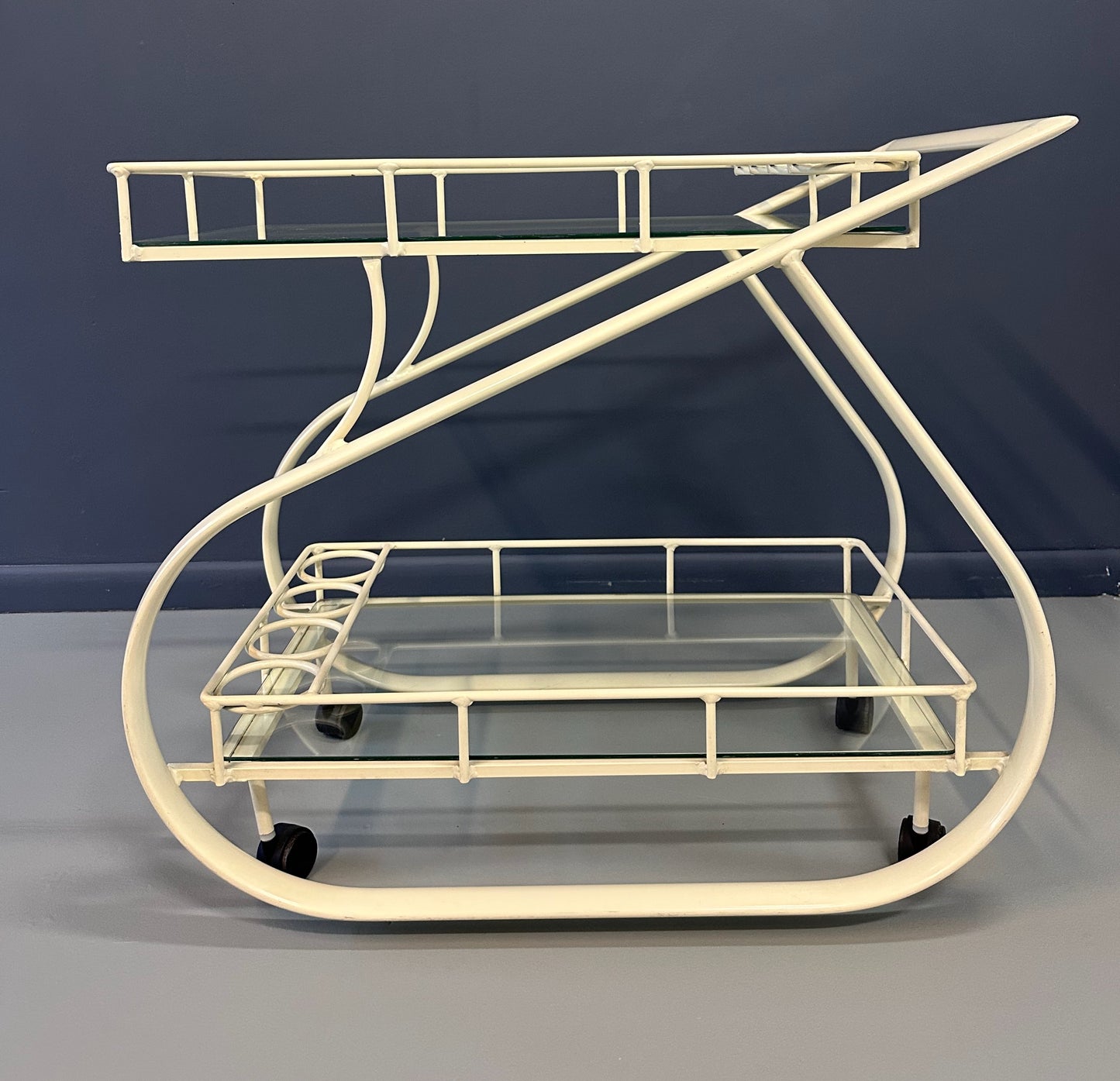Vintage 1980s postmodern two-tier bar cart with curvy metal frame and glass shelves, attributed to Woodard