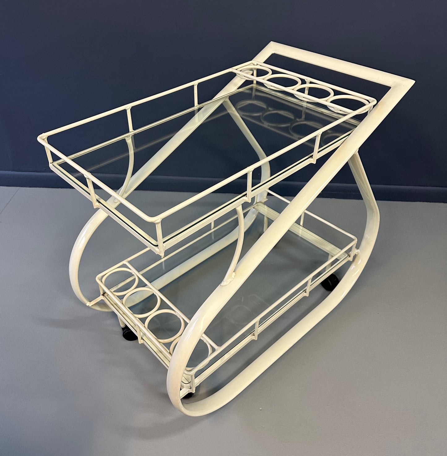 Vintage 1980s postmodern two-tier bar cart with curvy metal frame and glass shelves, attributed to Woodard