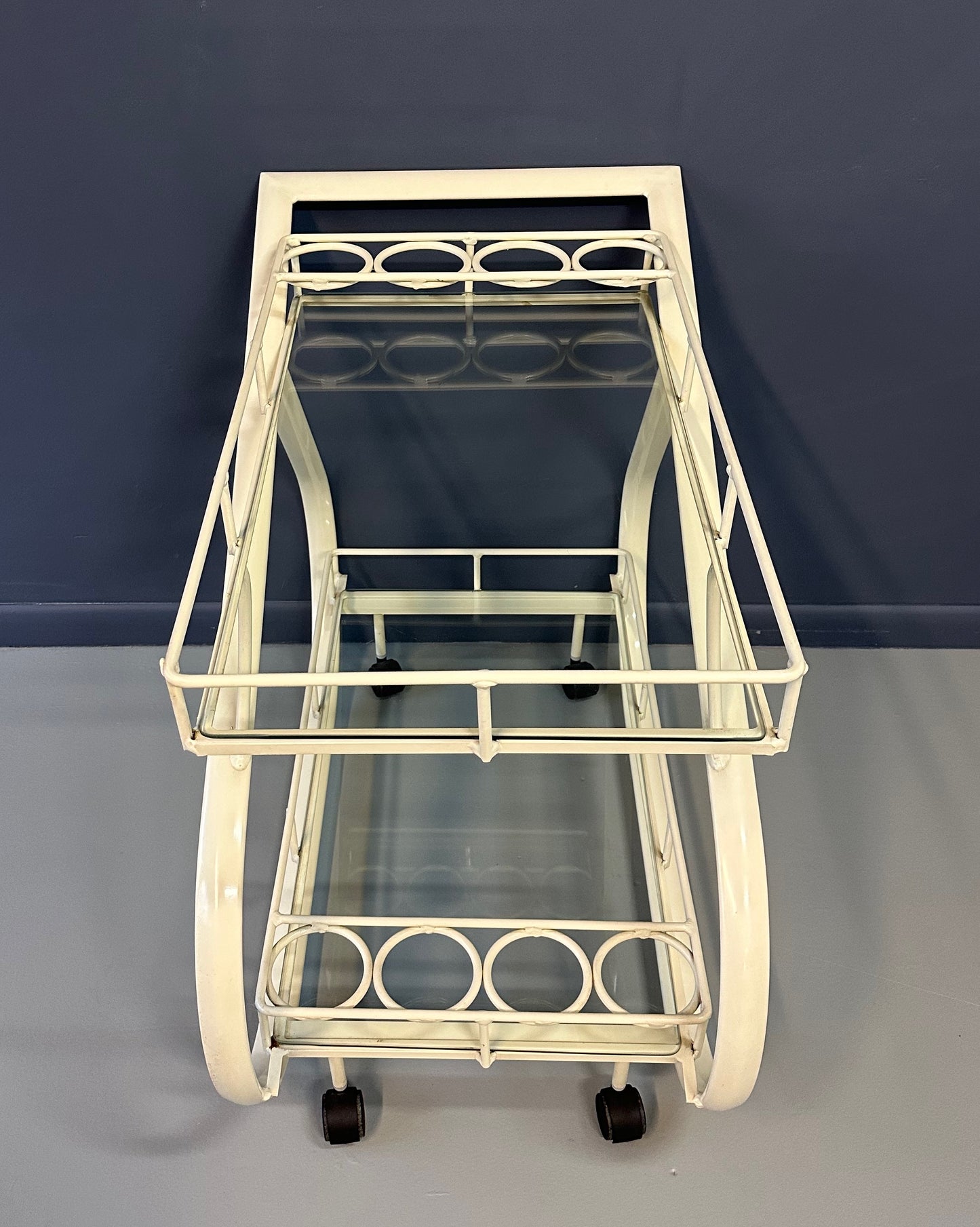 Vintage 1980s postmodern two-tier bar cart with curvy metal frame and glass shelves, attributed to Woodard