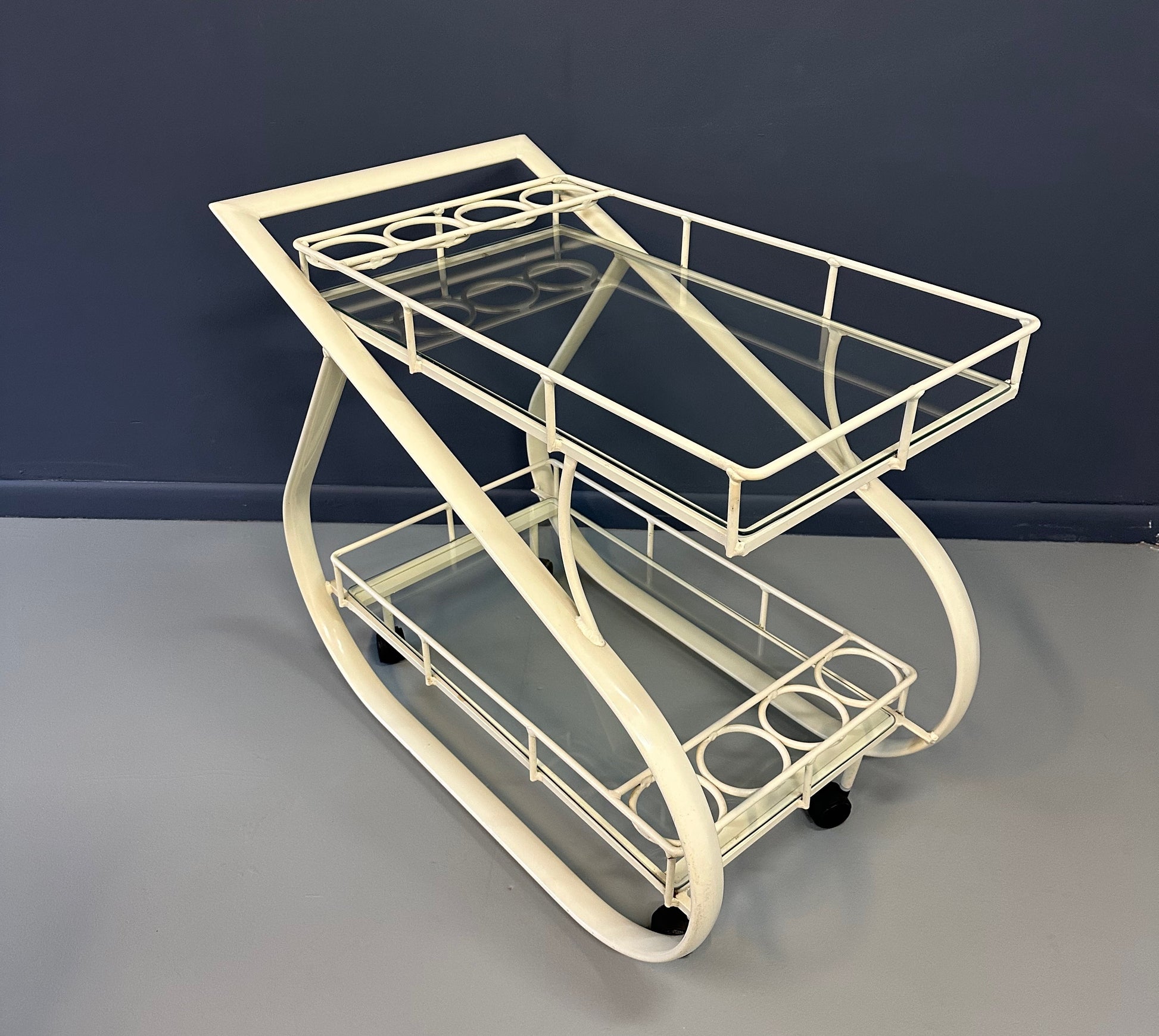Vintage 1980s postmodern two-tier bar cart with curvy metal frame and glass shelves, attributed to Woodard