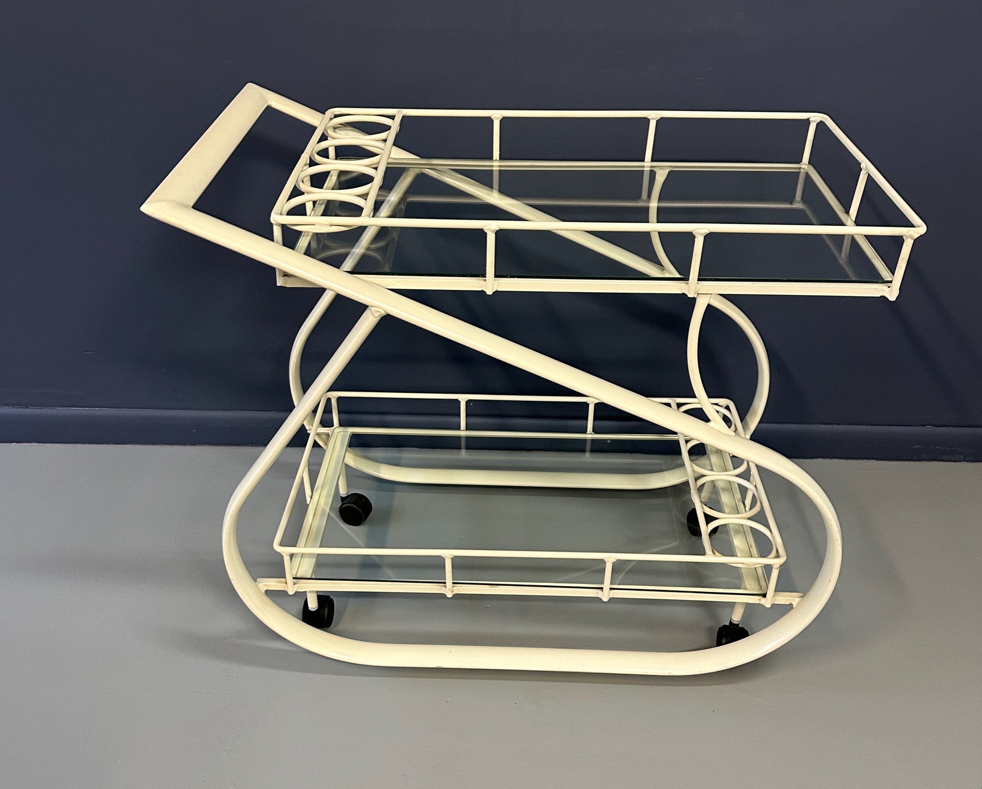 Vintage 1980s postmodern two-tier bar cart with curvy metal frame and glass shelves, attributed to Woodard