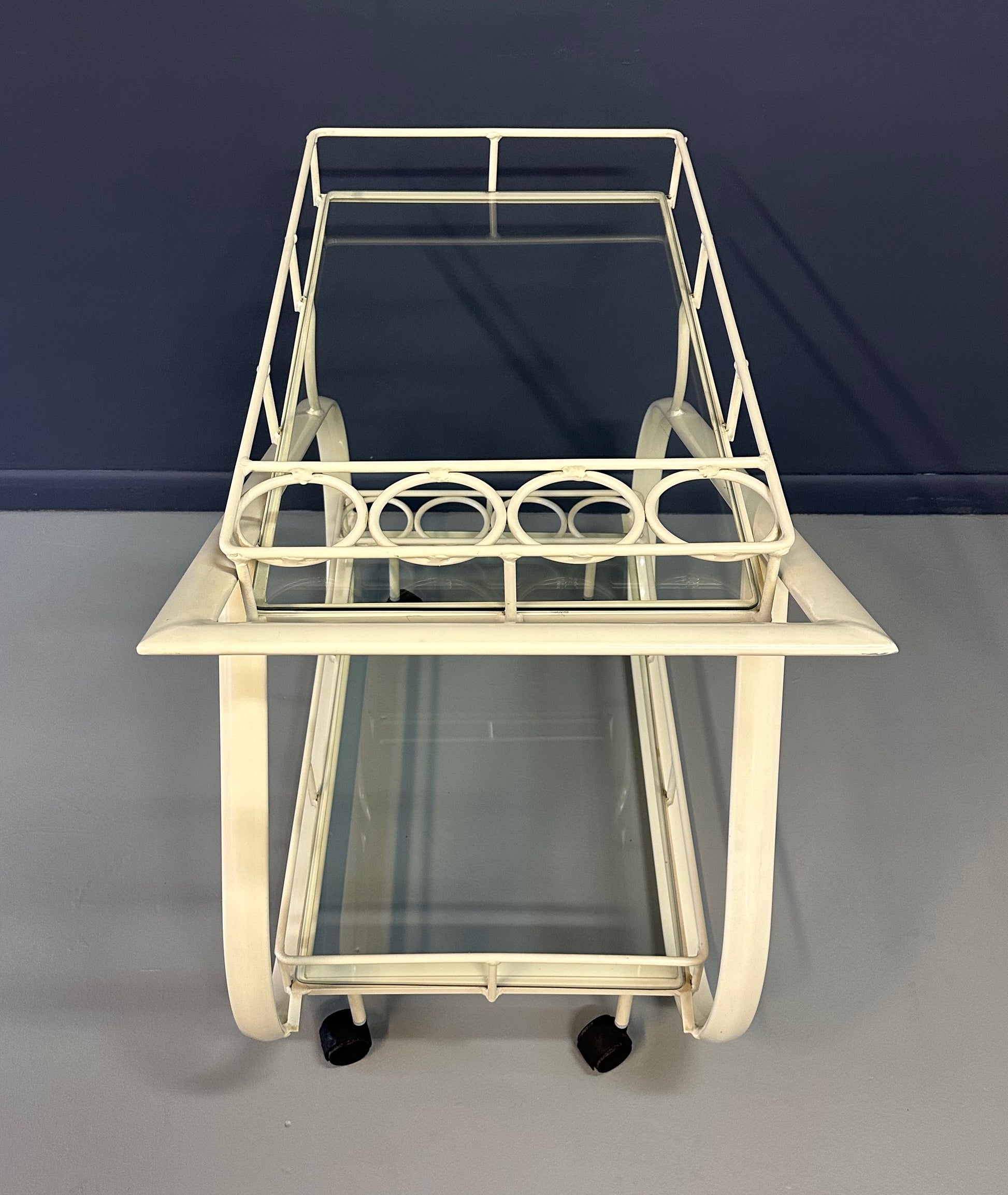 Vintage 1980s postmodern two-tier bar cart with curvy metal frame and glass shelves, attributed to Woodard