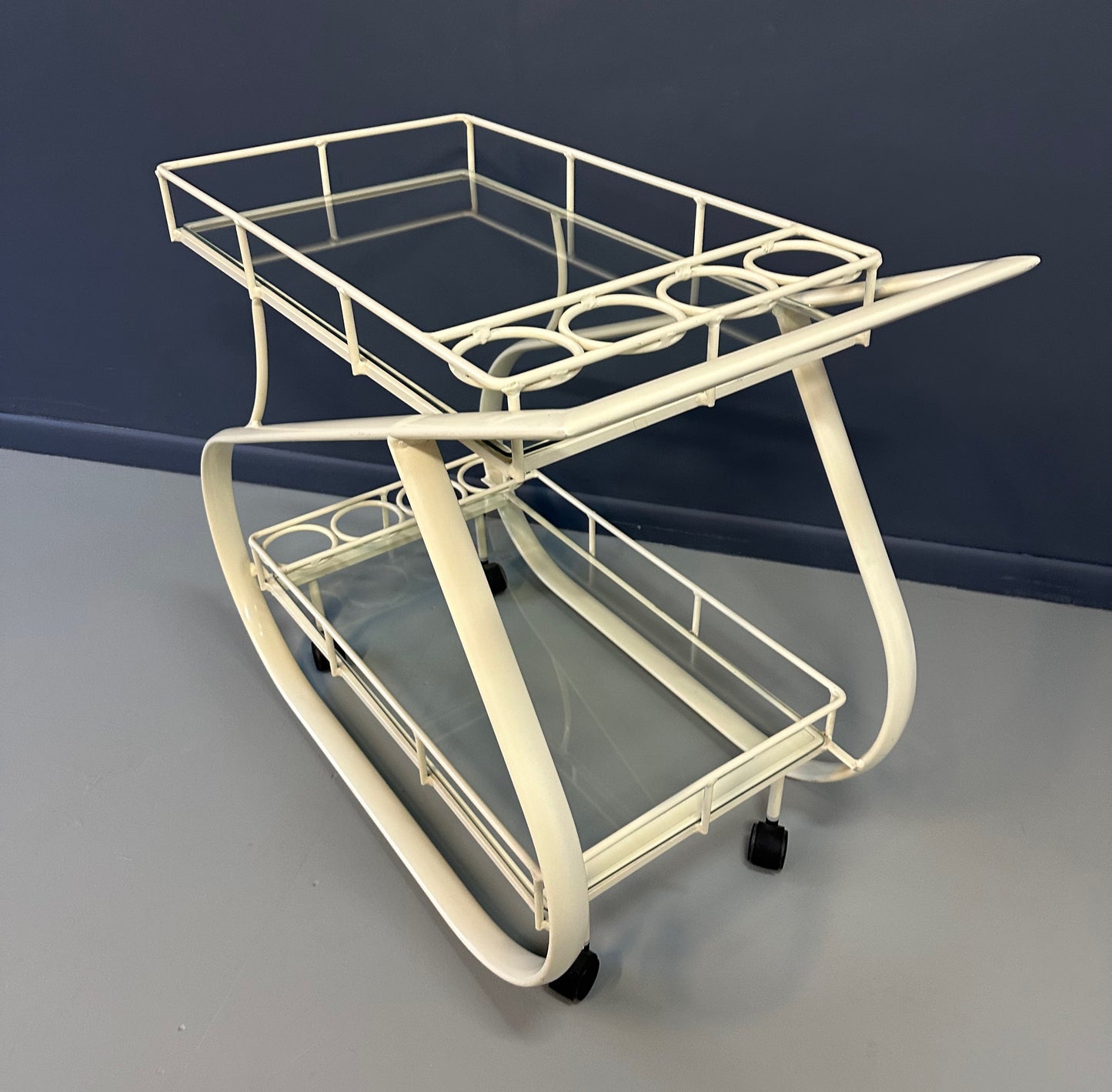 Vintage 1980s postmodern two-tier bar cart with curvy metal frame and glass shelves, attributed to Woodard