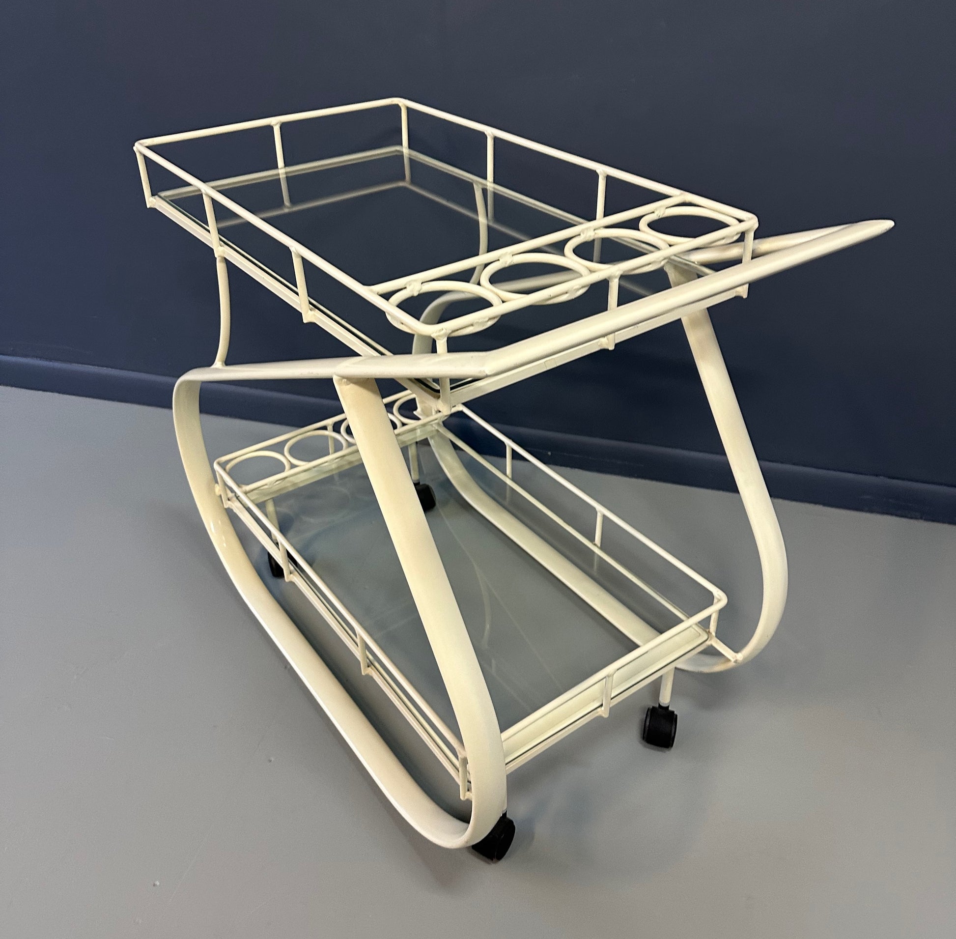Vintage 1980s postmodern two-tier bar cart with curvy metal frame and glass shelves, attributed to Woodard