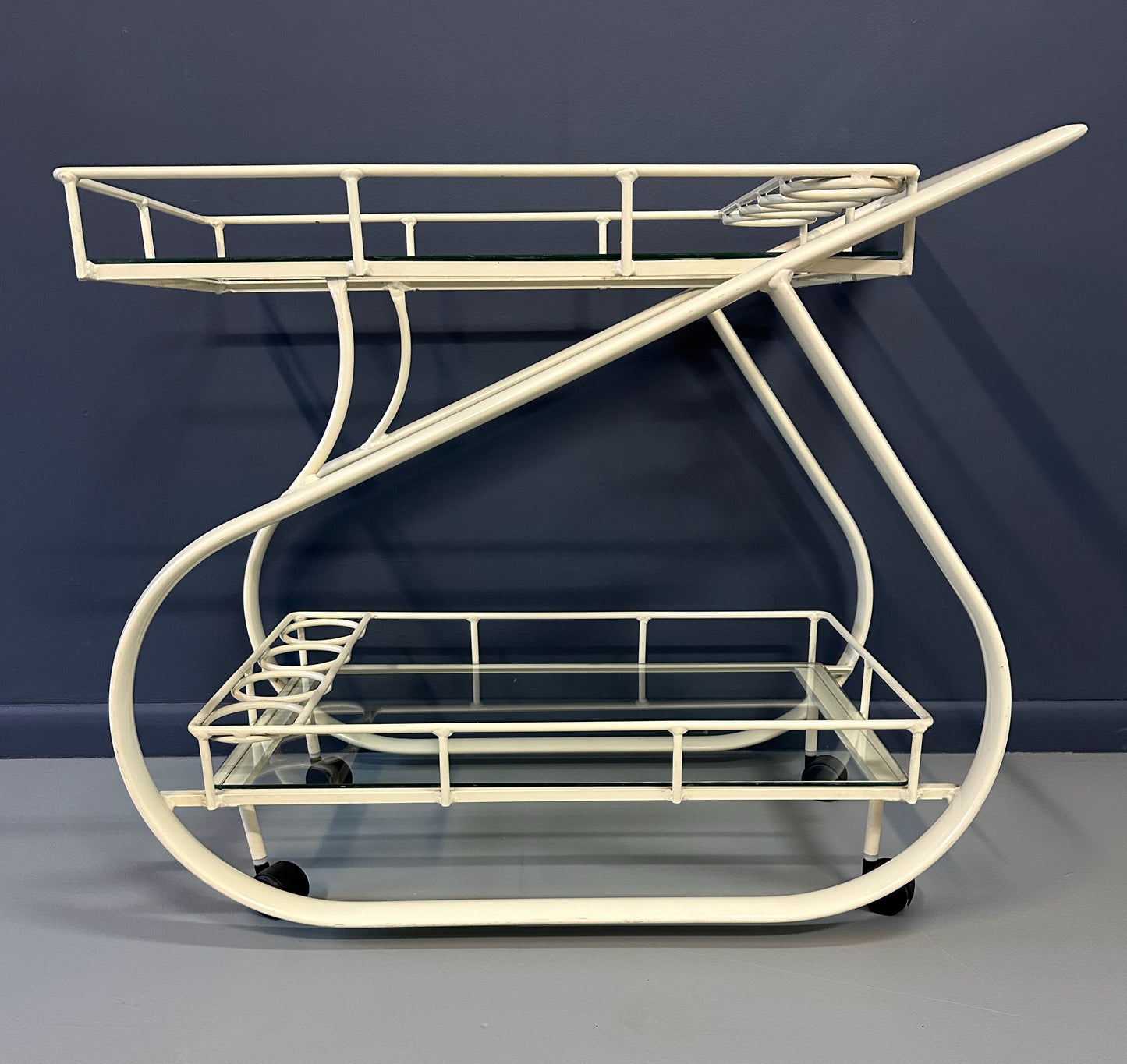 Vintage 1980s postmodern two-tier bar cart with curvy metal frame and glass shelves, attributed to Woodard