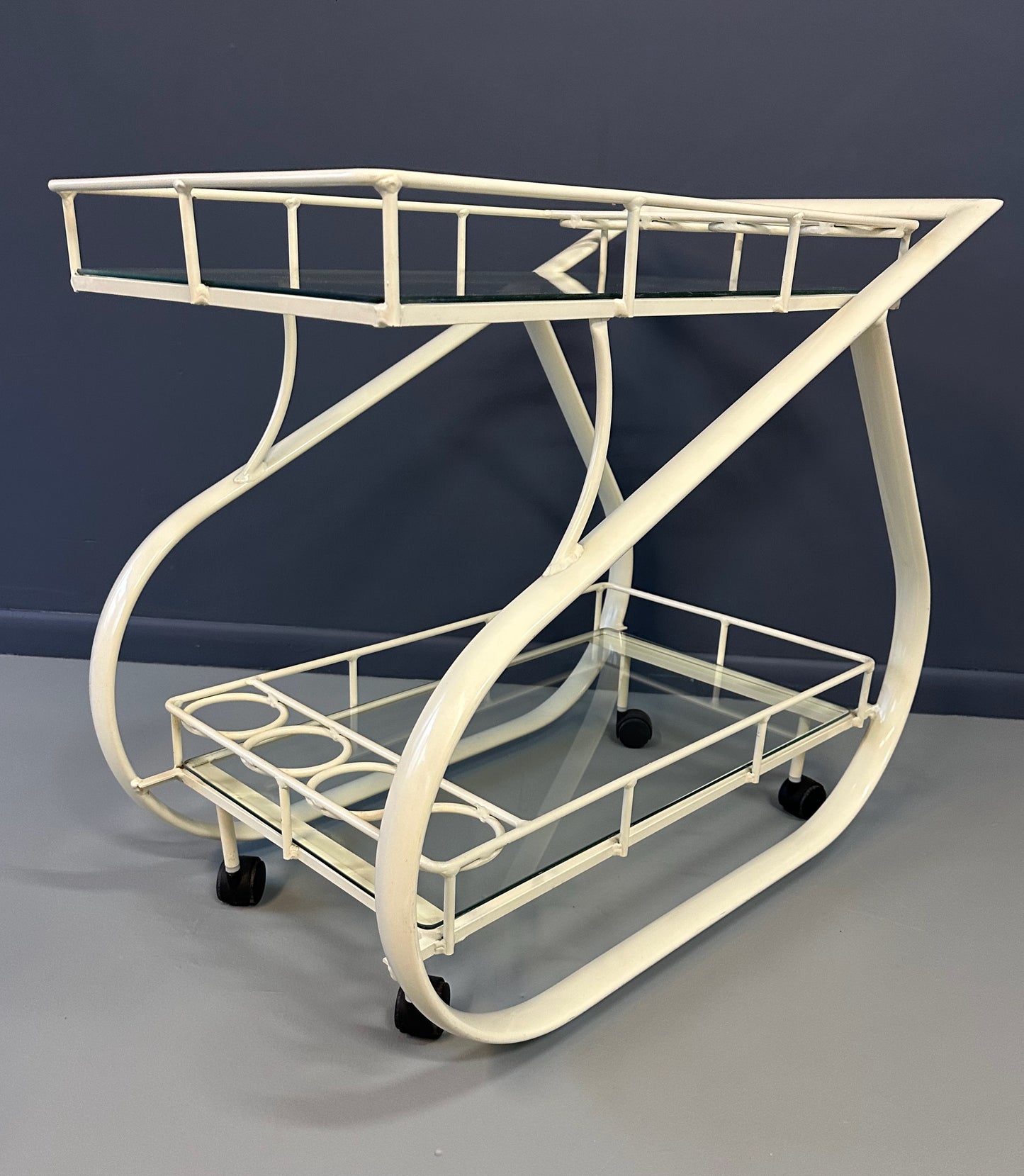 Vintage 1980s postmodern two-tier bar cart with curvy metal frame and glass shelves, attributed to Woodard
